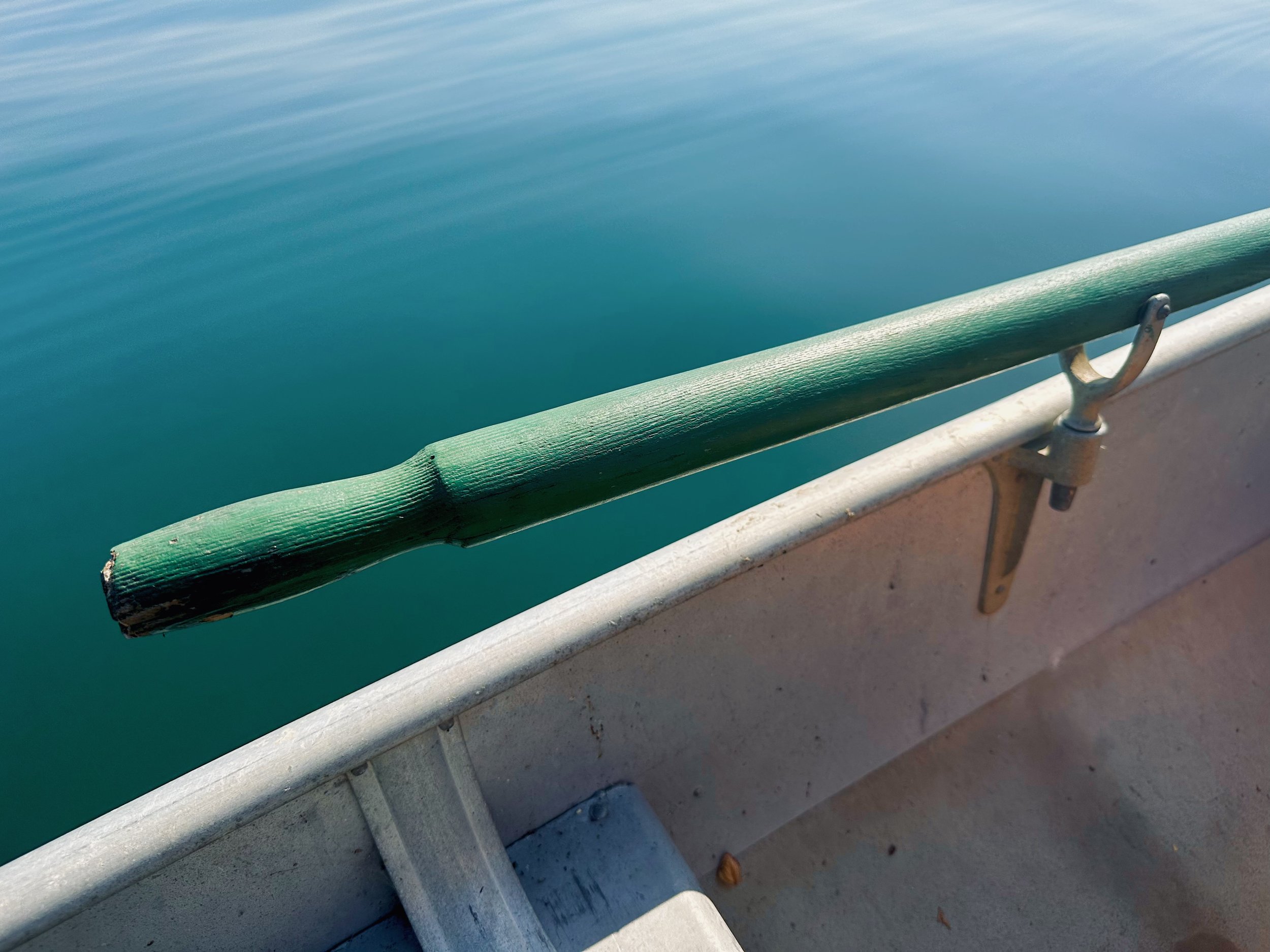 Image taken from a boat showing a green oar and blue-green water in Penn Yan, NY