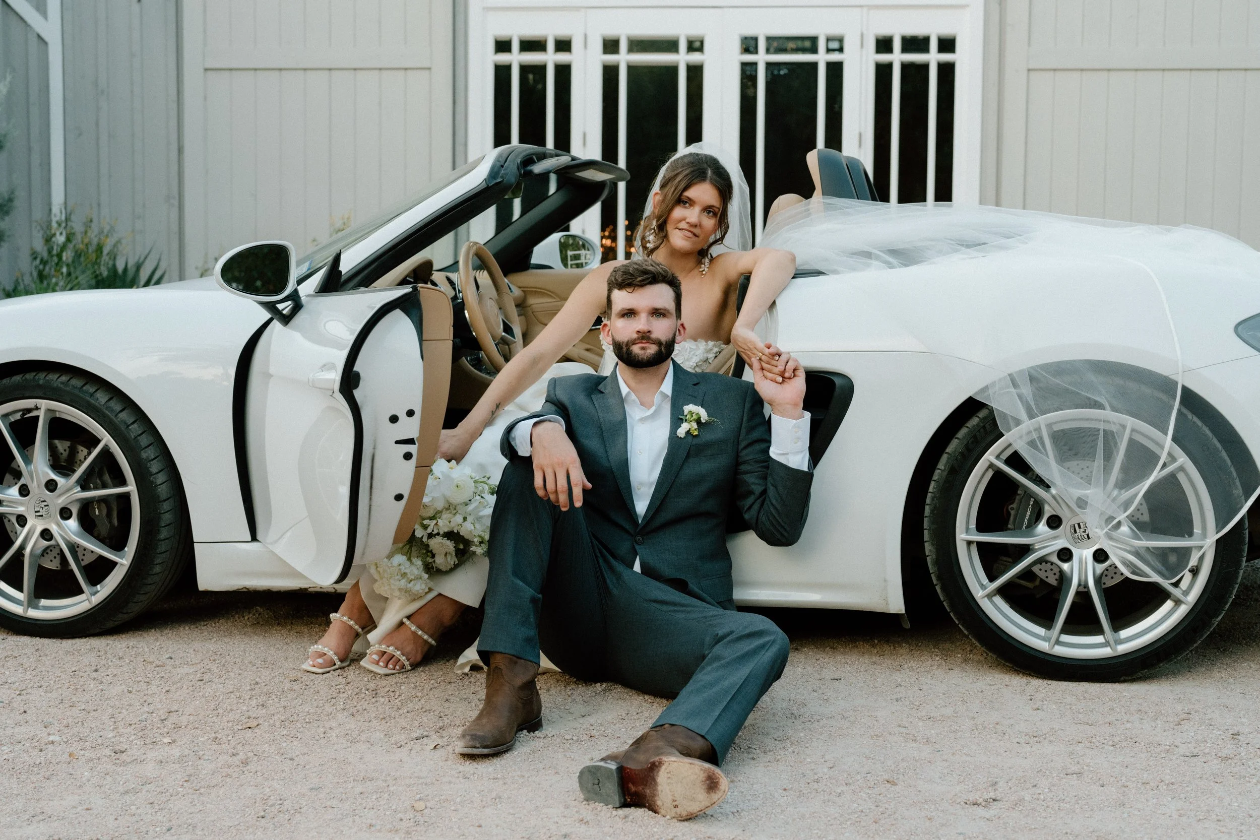 Couple pose with a porsche at The Addison Grove wedding venue in Texas Hill Country