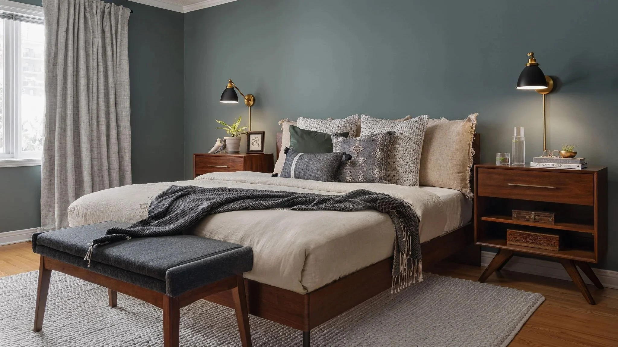  Mid-century modern bedroom with blue walls and wood floors, featuring a cozy atmosphere and natural elements.