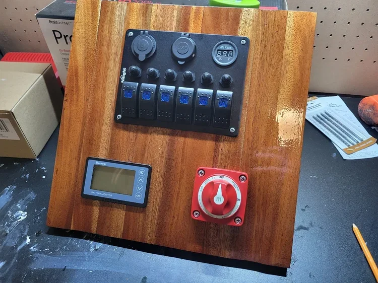 Wooden control panel with multiple switches, a digital display, and a large red and white rotary switch.