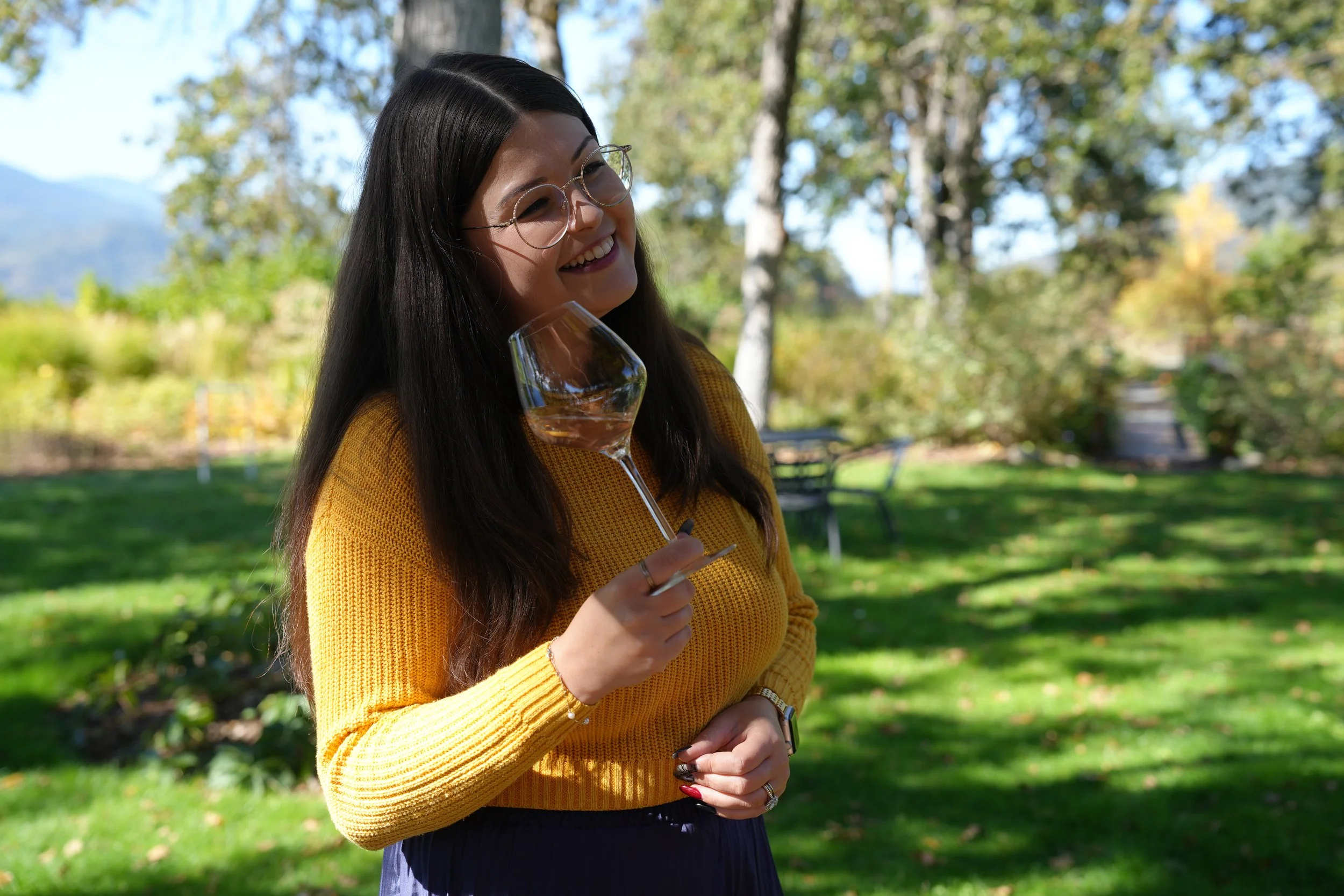 WSET Level 3 certified wine educator Faith listening to a guest with a glass of wine in hand on an Applegate wine tour.