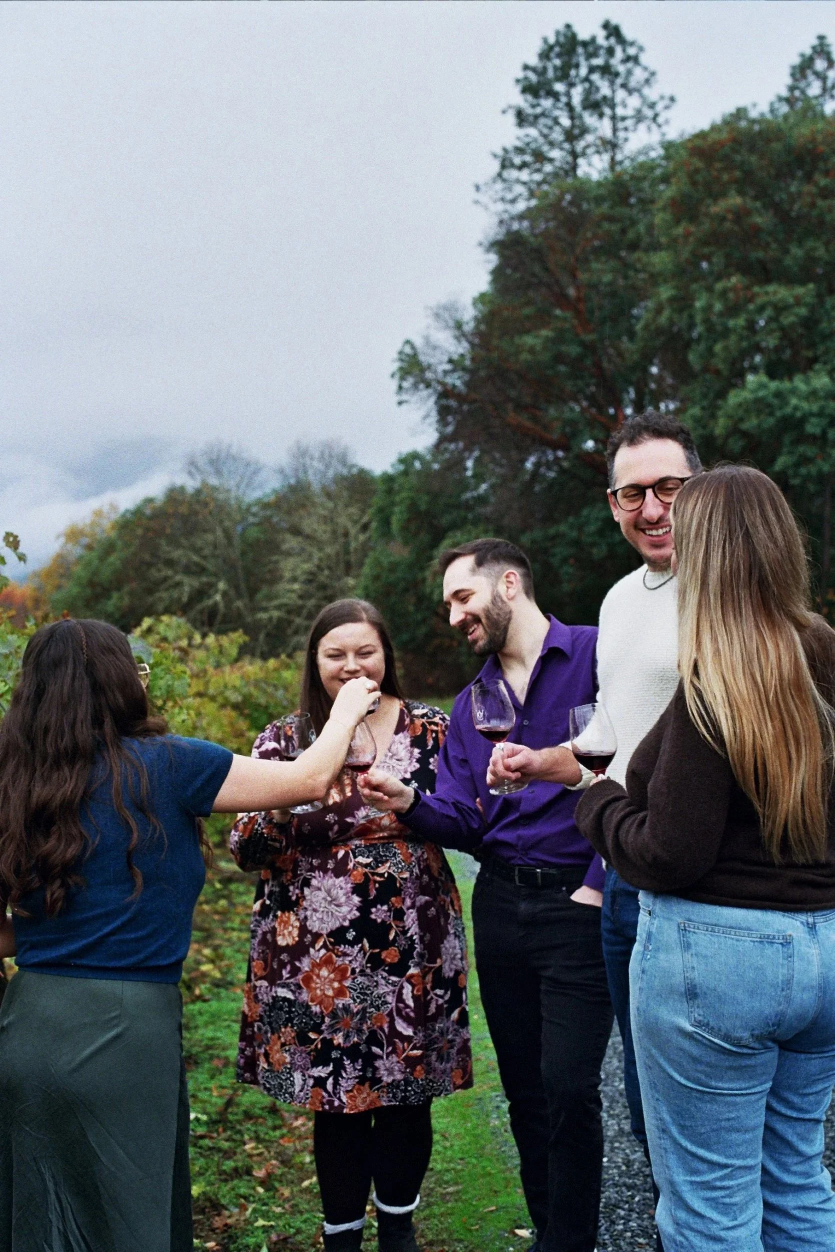 group enjoying wine tasting southern oregon with glasses of red wine