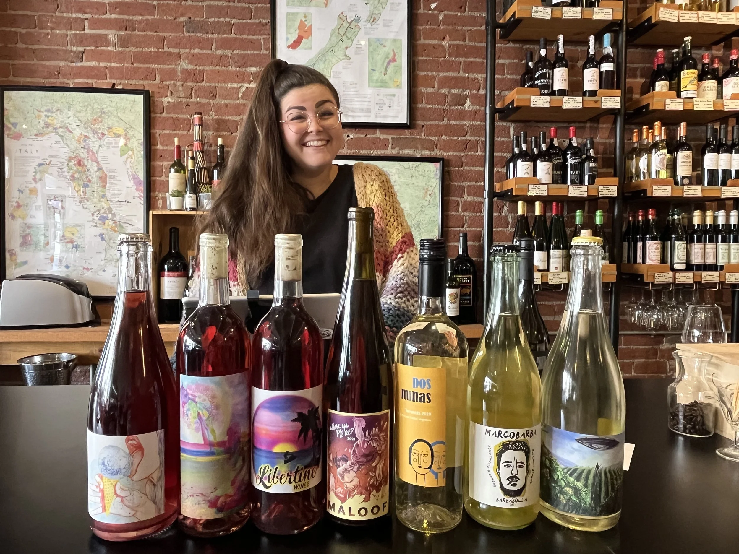 Faith standing behind a selection of unique international wines.
