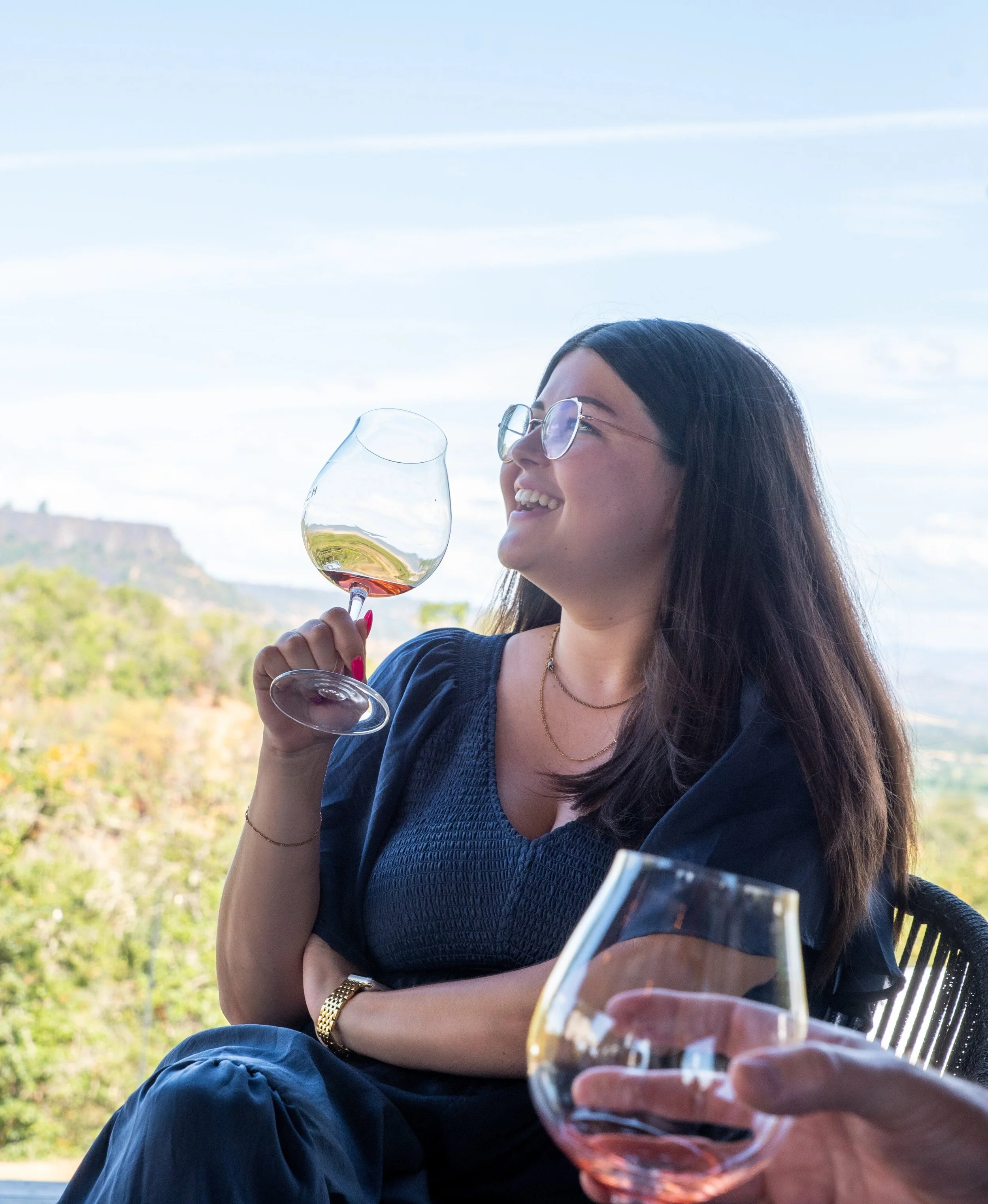 WSET 3 Certified Wine Educator Faith Lemire-Baeten smiling with a glass of wine in hand on a Rogue Valley Wine Tours, wine tours Southern Oregon.
