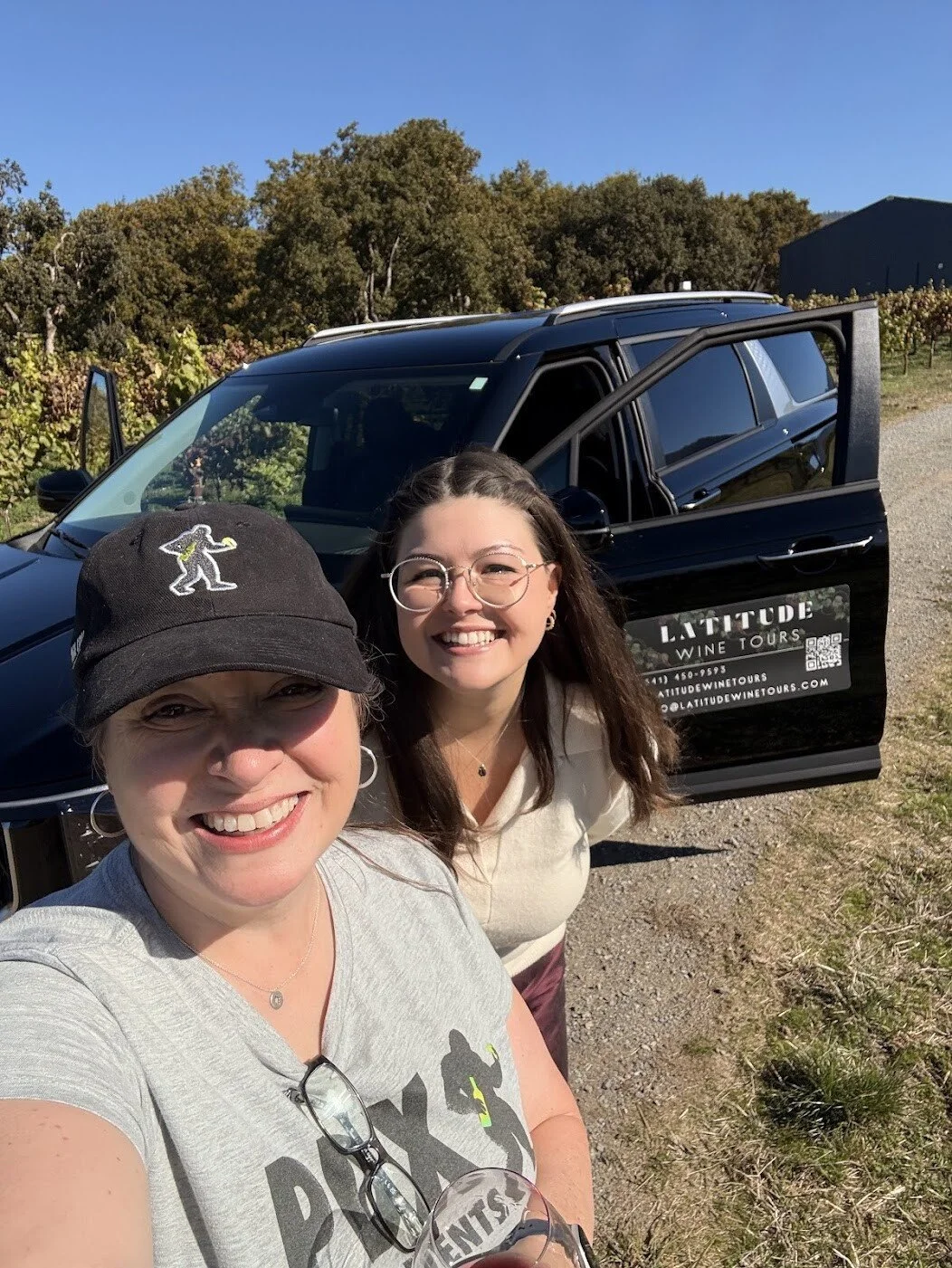 WSET Level 3-certified wine educator Faith poses in a selfie with a guest in front of the tour van on one of our Rogue Valley wine tours