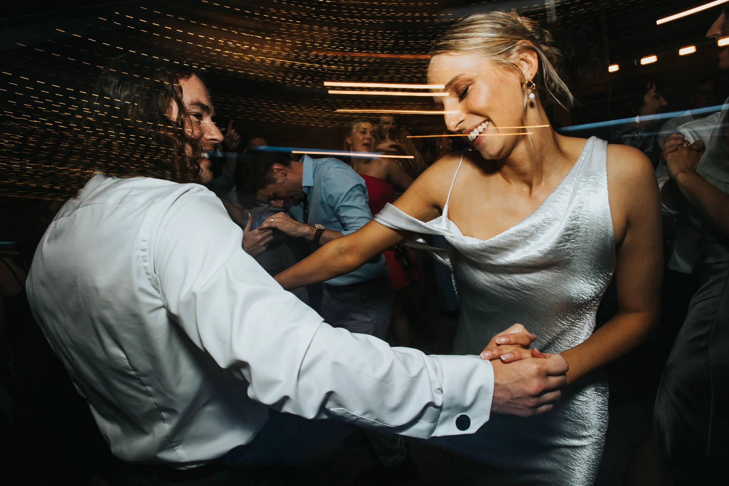 People dancing and enjoying themselves at a lively party or nightclub with colorful lights and motion effects.