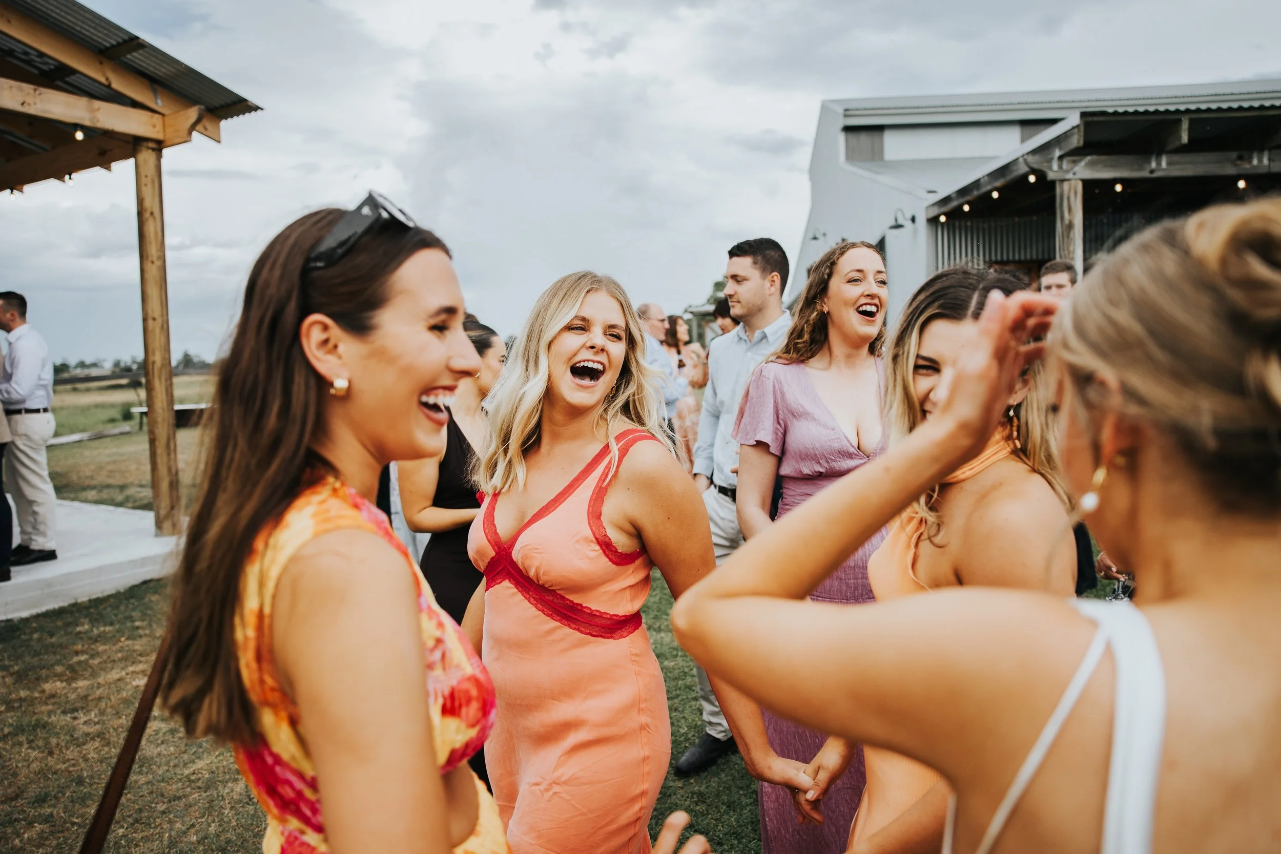 People outside at a social gathering, laughing and enjoying themselves.