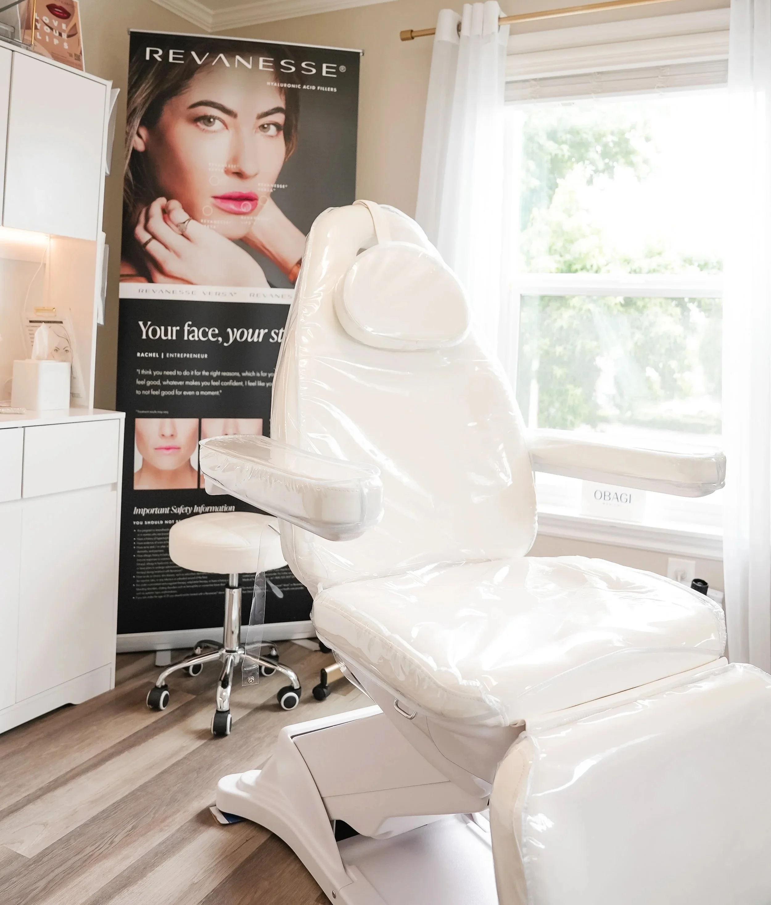 A white examination chair in a skincare or medical office with a poster in the background advertising Revance skincare products.