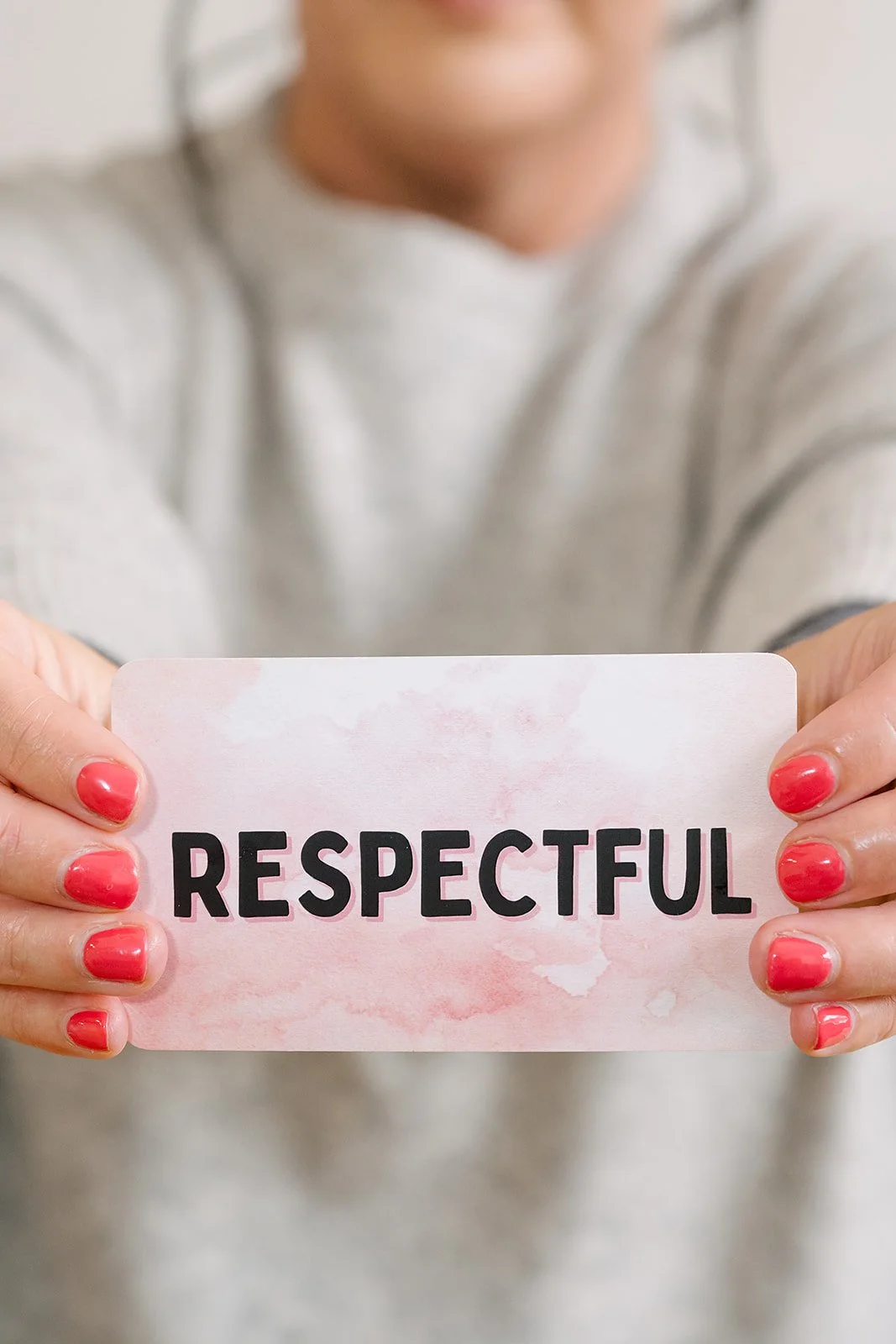 Woman holding a card with the word ‘Respectful'