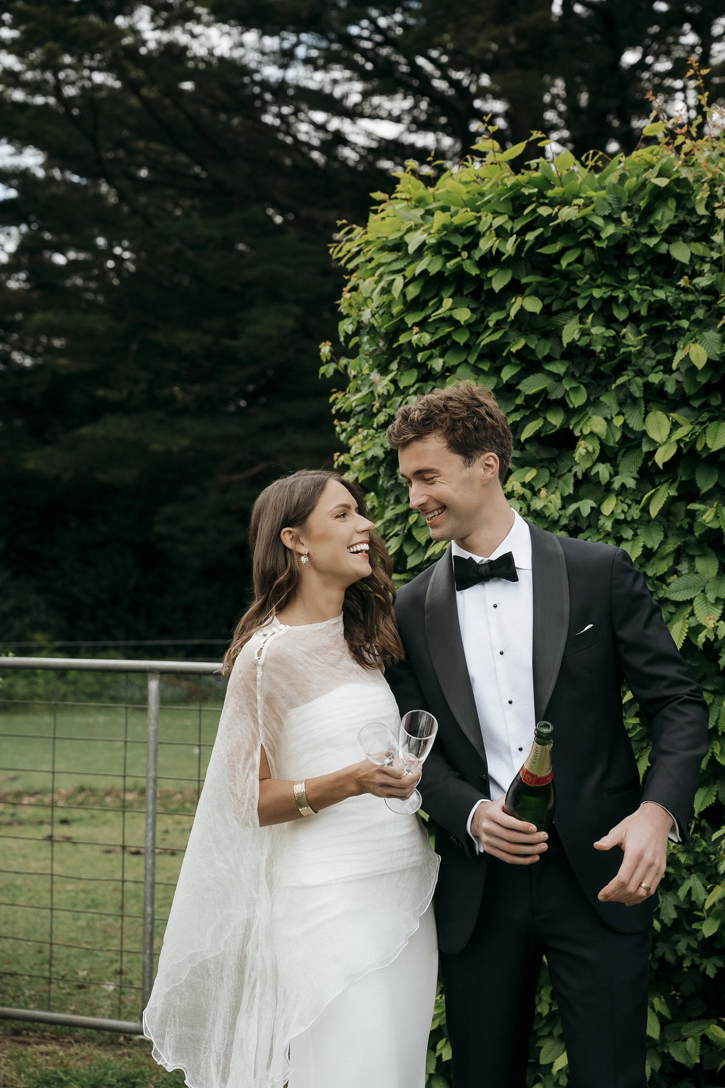 Newlyweds popping a bottle of champagne after their ceremony