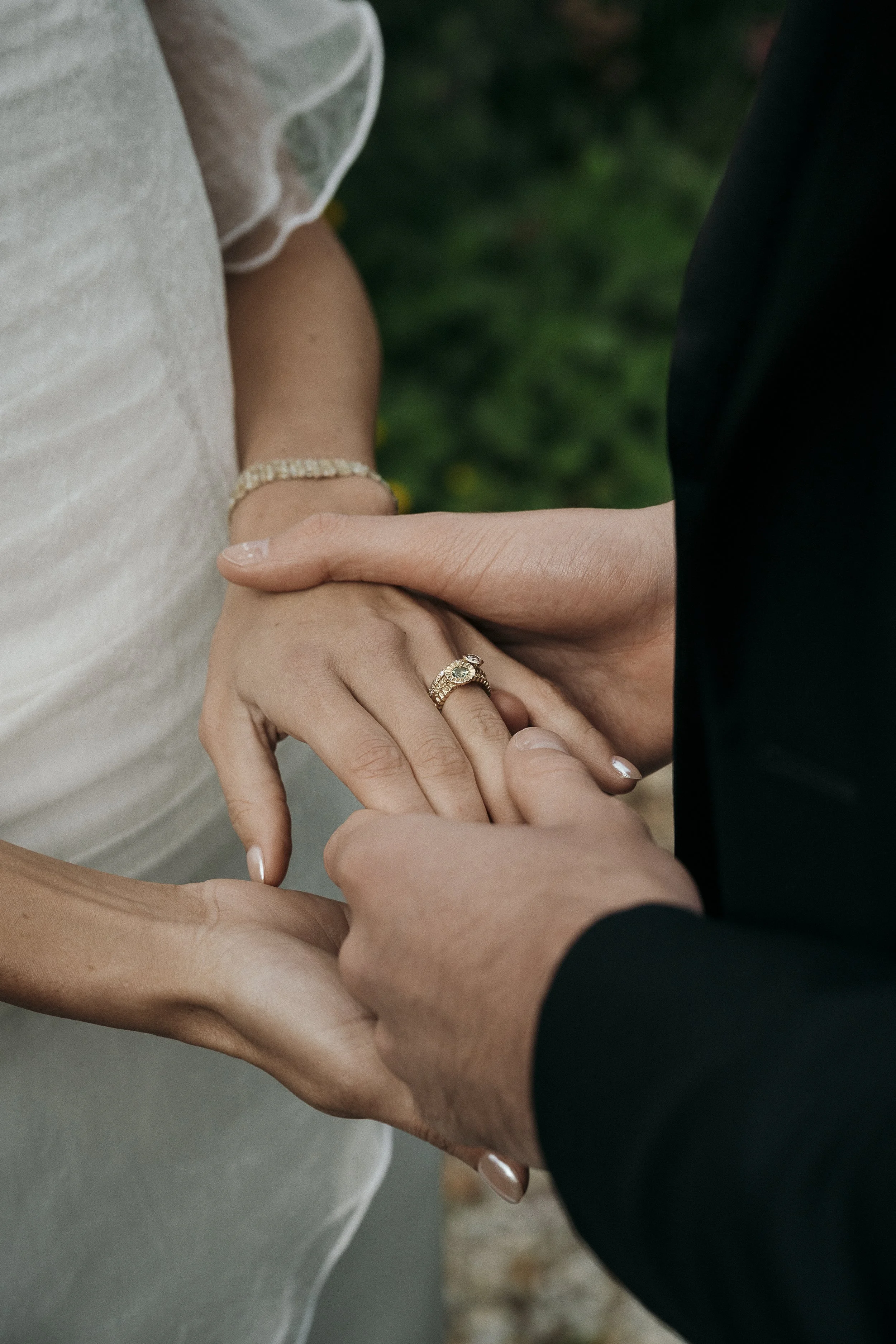Close-up of hands during the ceremony, showing rings and emotion