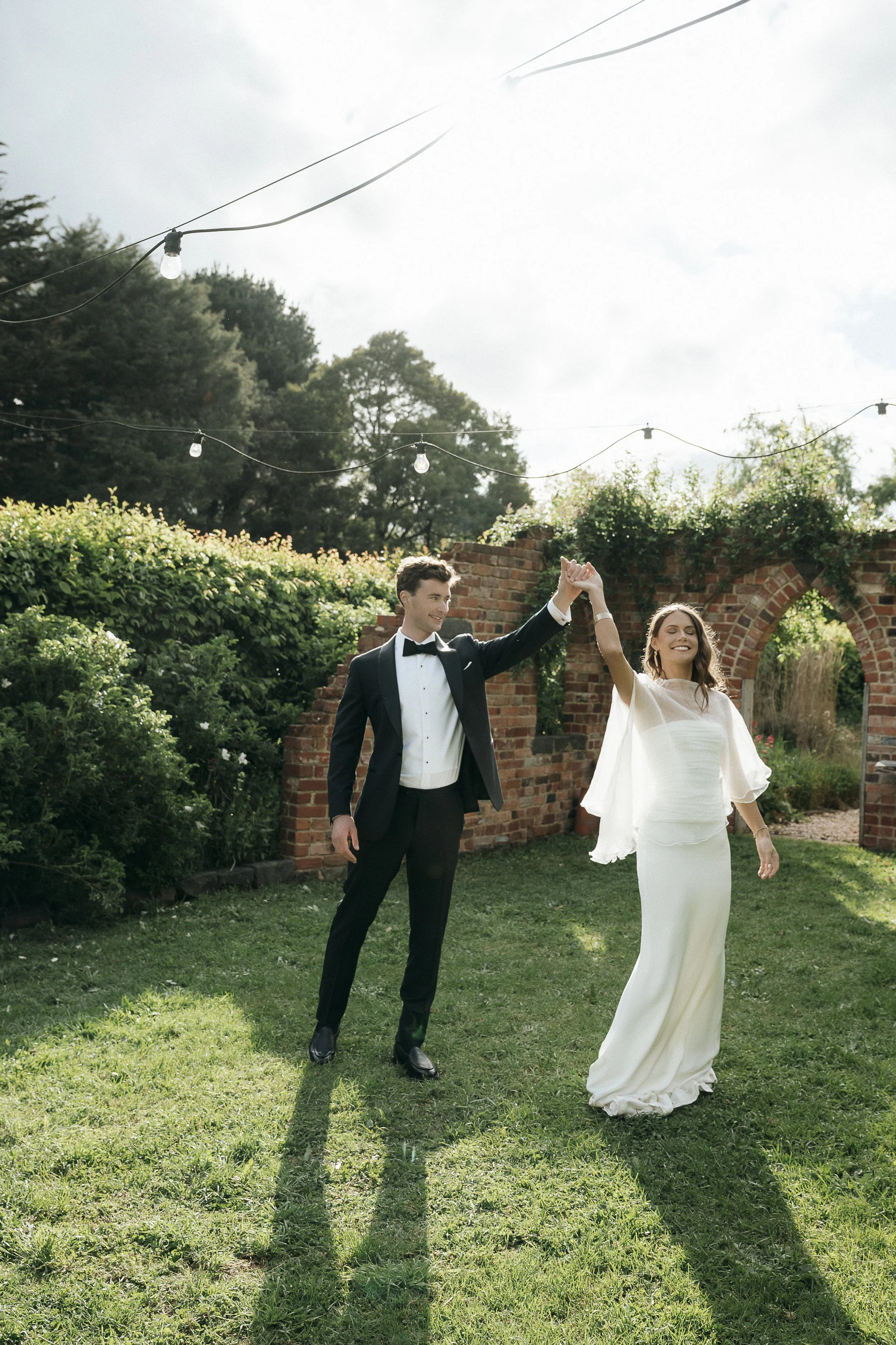 couple dancing in the sunshine and dramatic light in the gardens