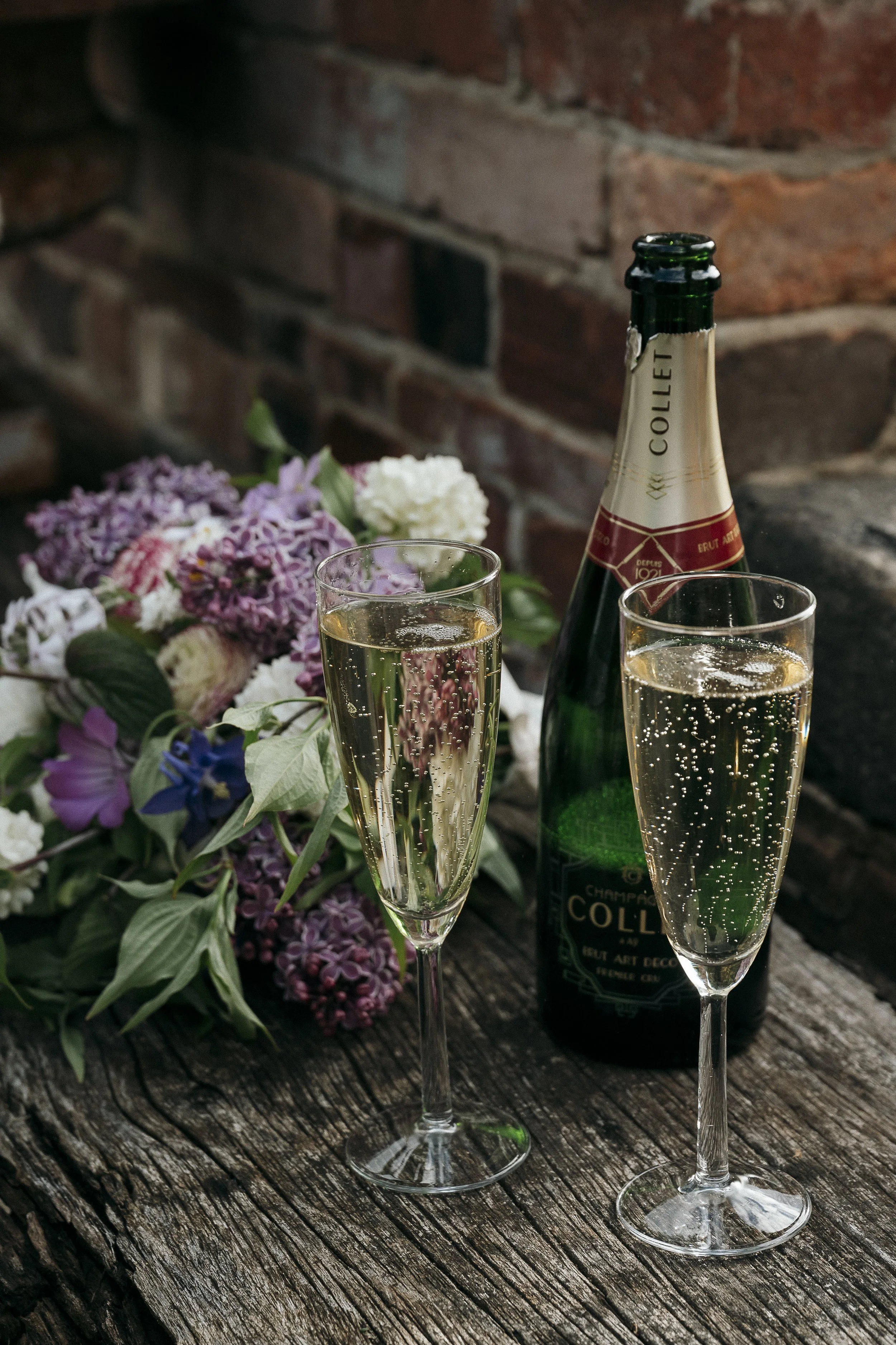 Detail shot of brides bouquet champagne bottle and two glasses