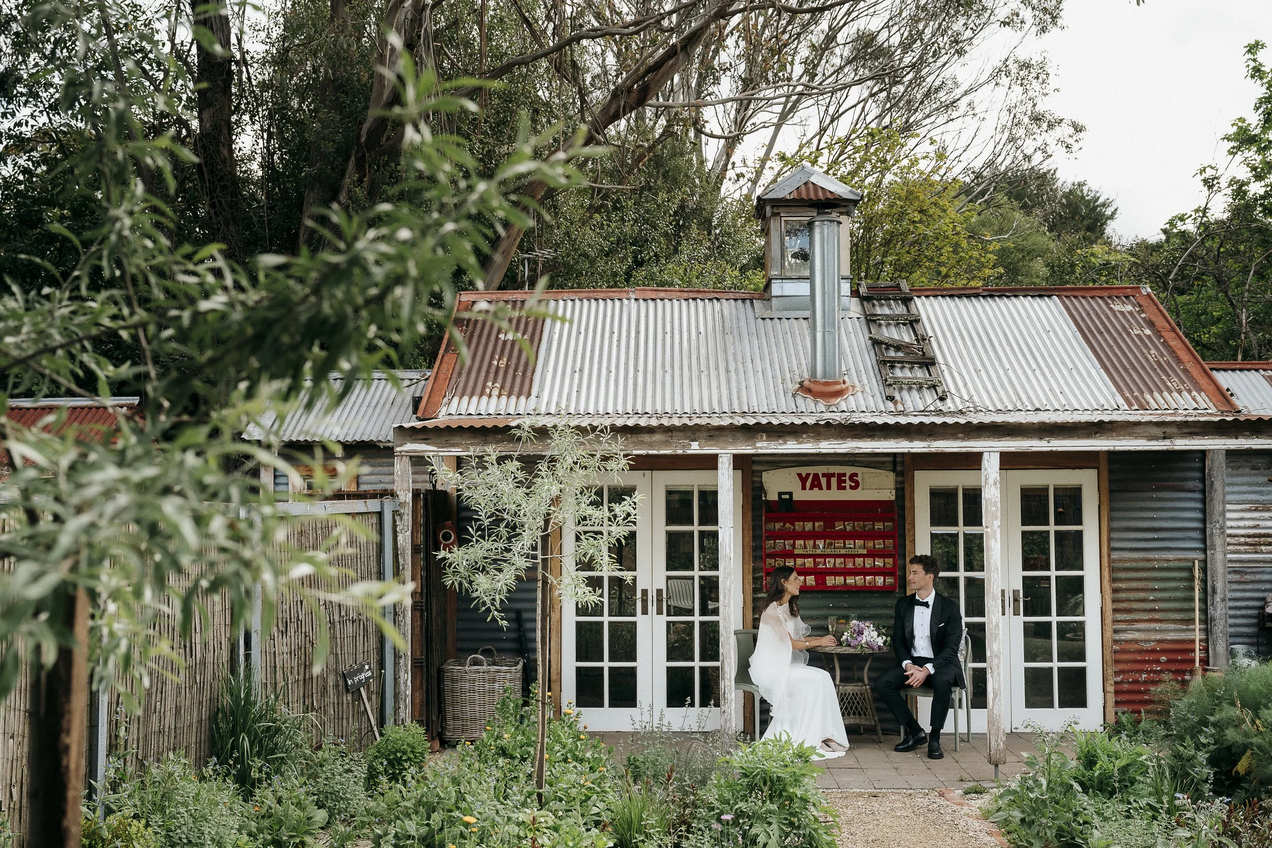 Couple sitting on the verandah of the potting shed enjoying eachothers company and a glass of champagne