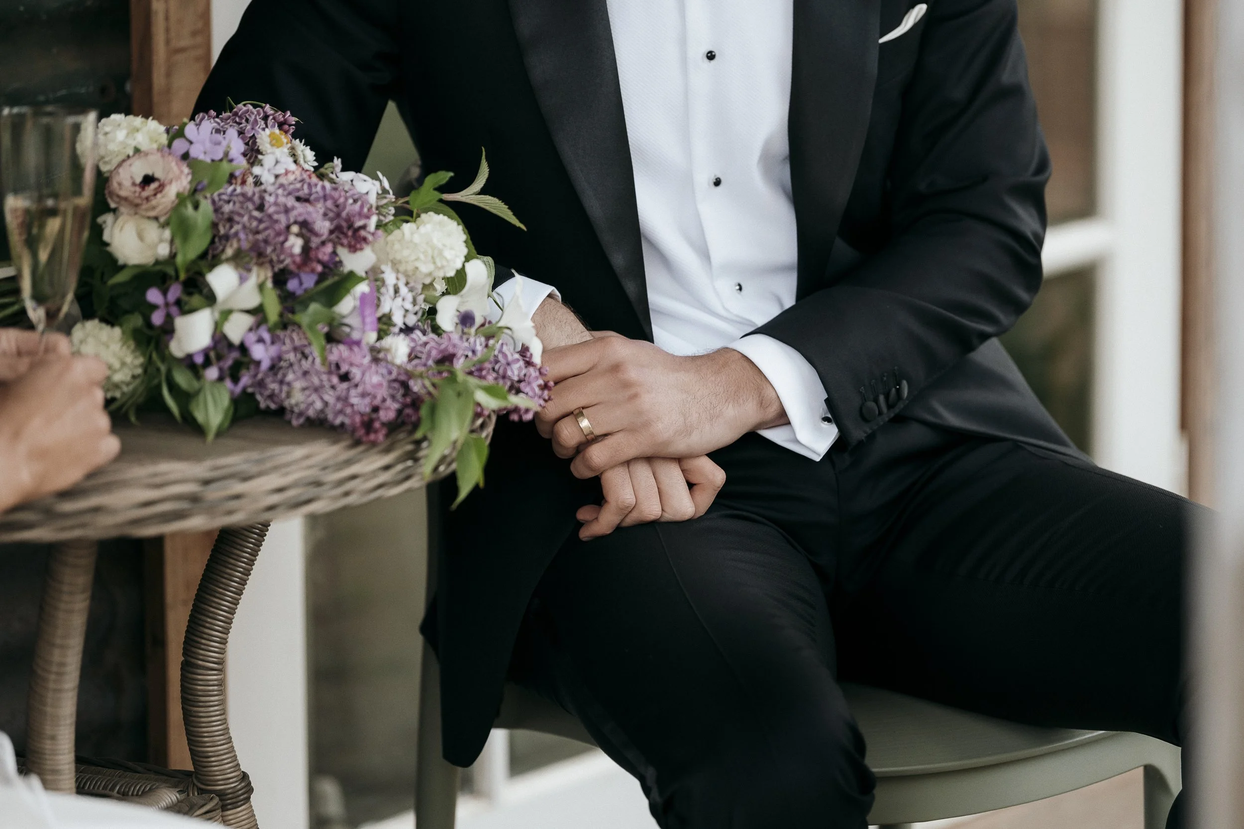 detail shot of grooms hands and wedding band 