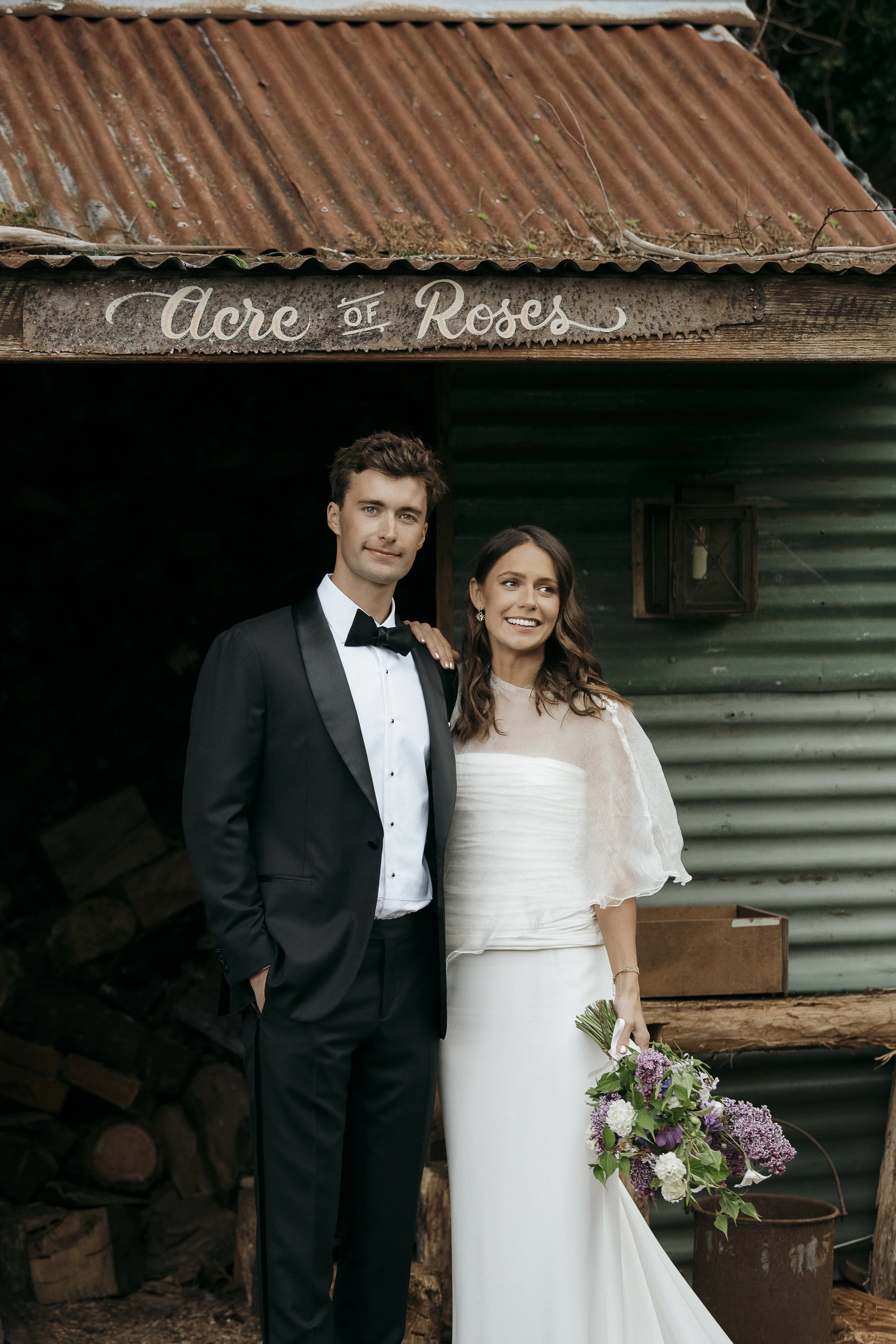 bride and groom portrait in front of wood shed with calligraphy Acre of Roses