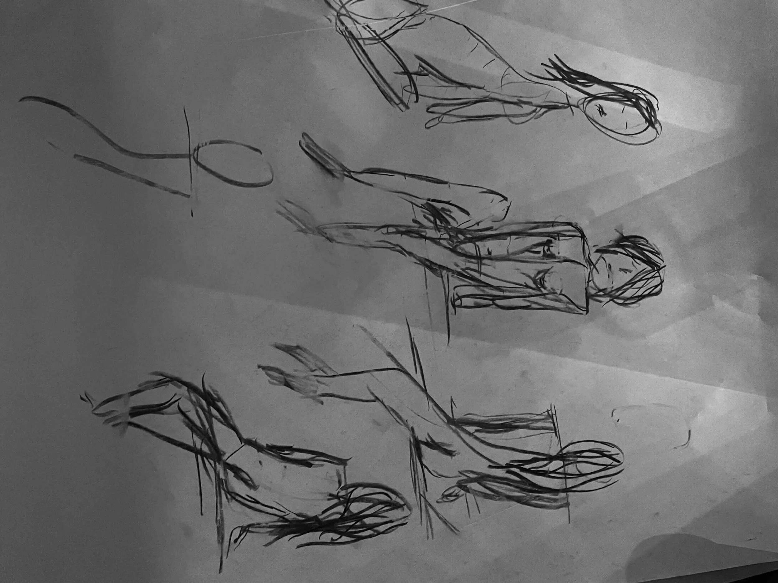 Sketch of multiple figures, some in athletic poses, on a piece of paper.