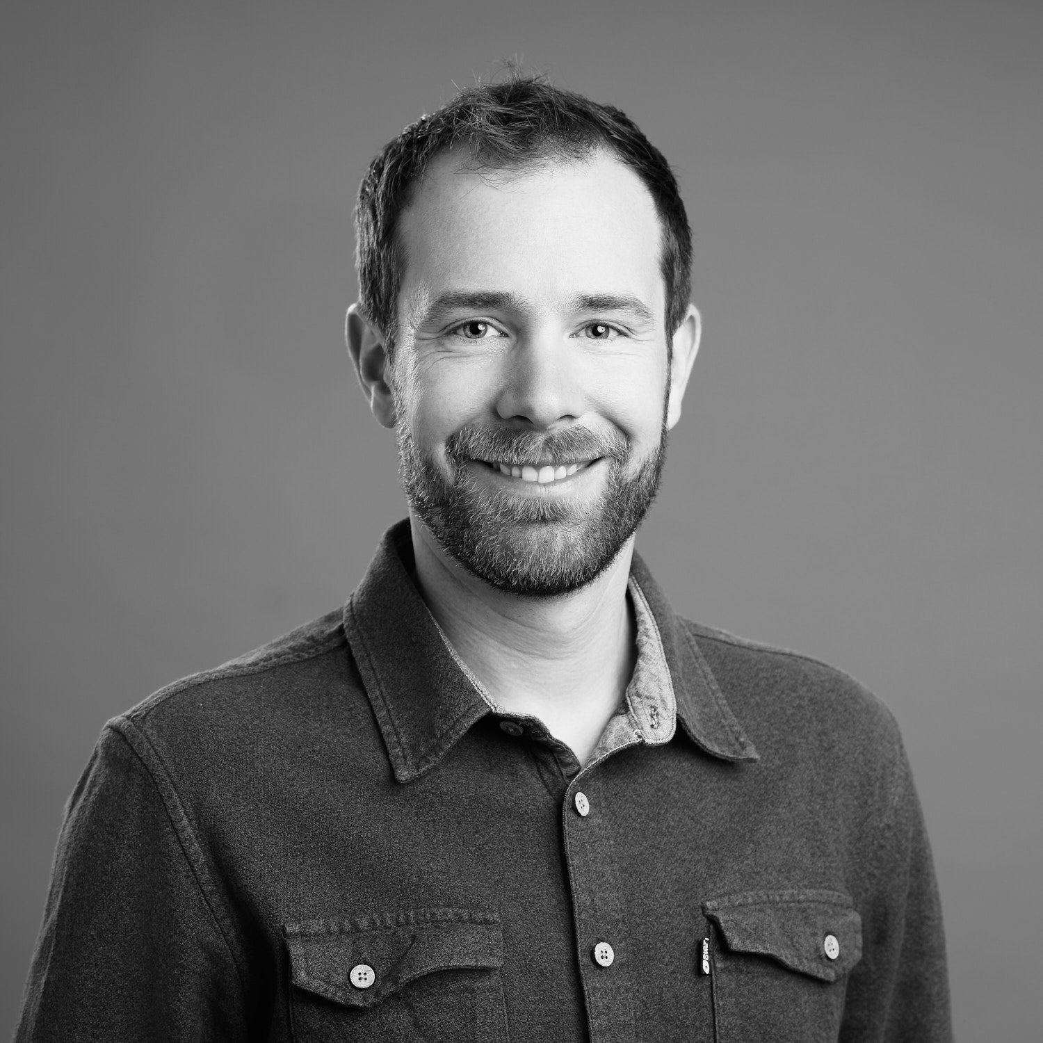 LinkedIn Portrait eines Mannes vor grauem Hintergrund im Studio