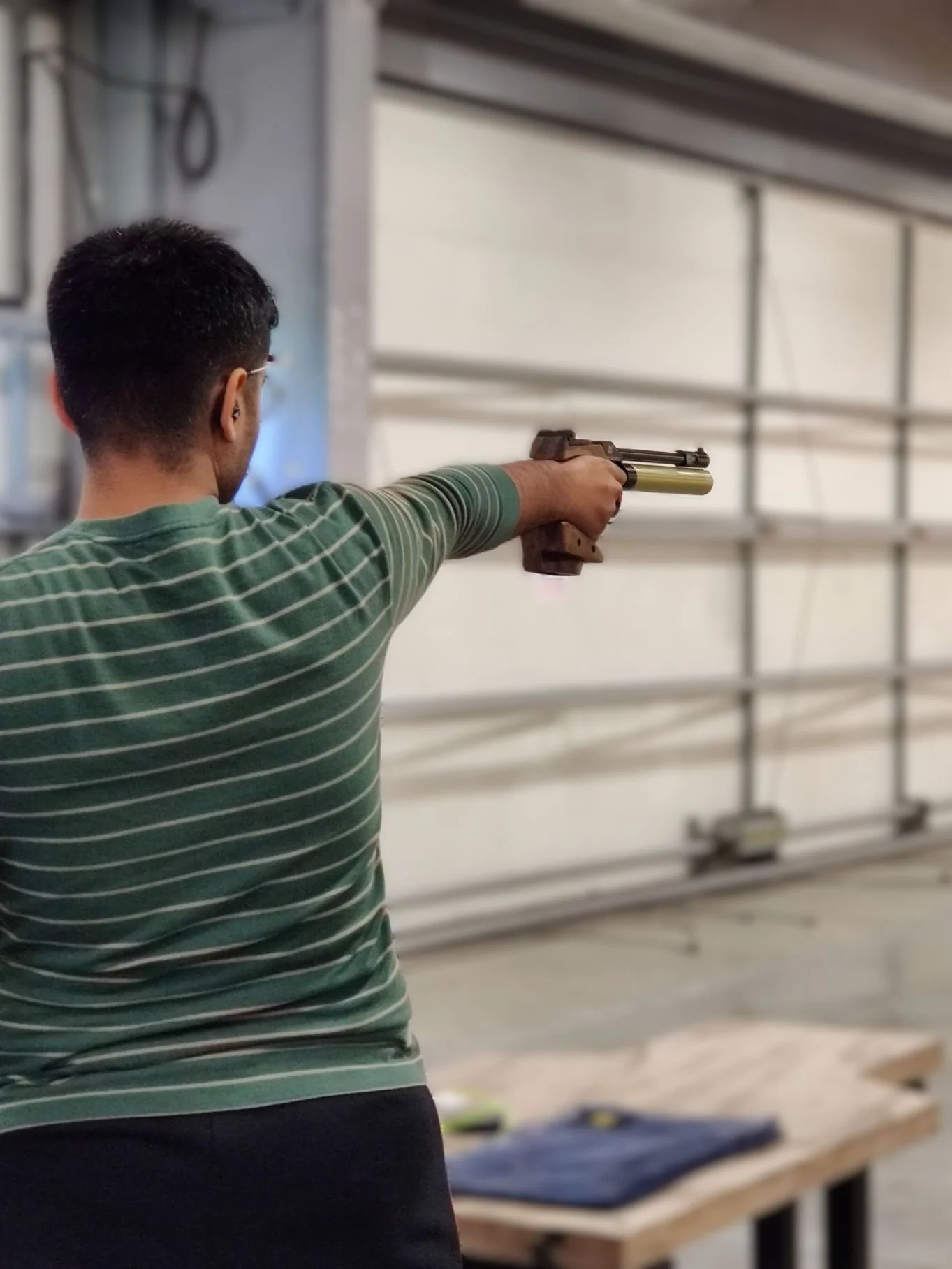 A man on the firing point competing in a pistol event at one of NSRA Bisley's ranges.