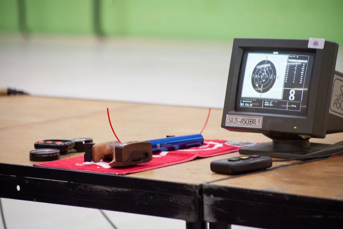 a pistol lying on the firing point table with a score screen
