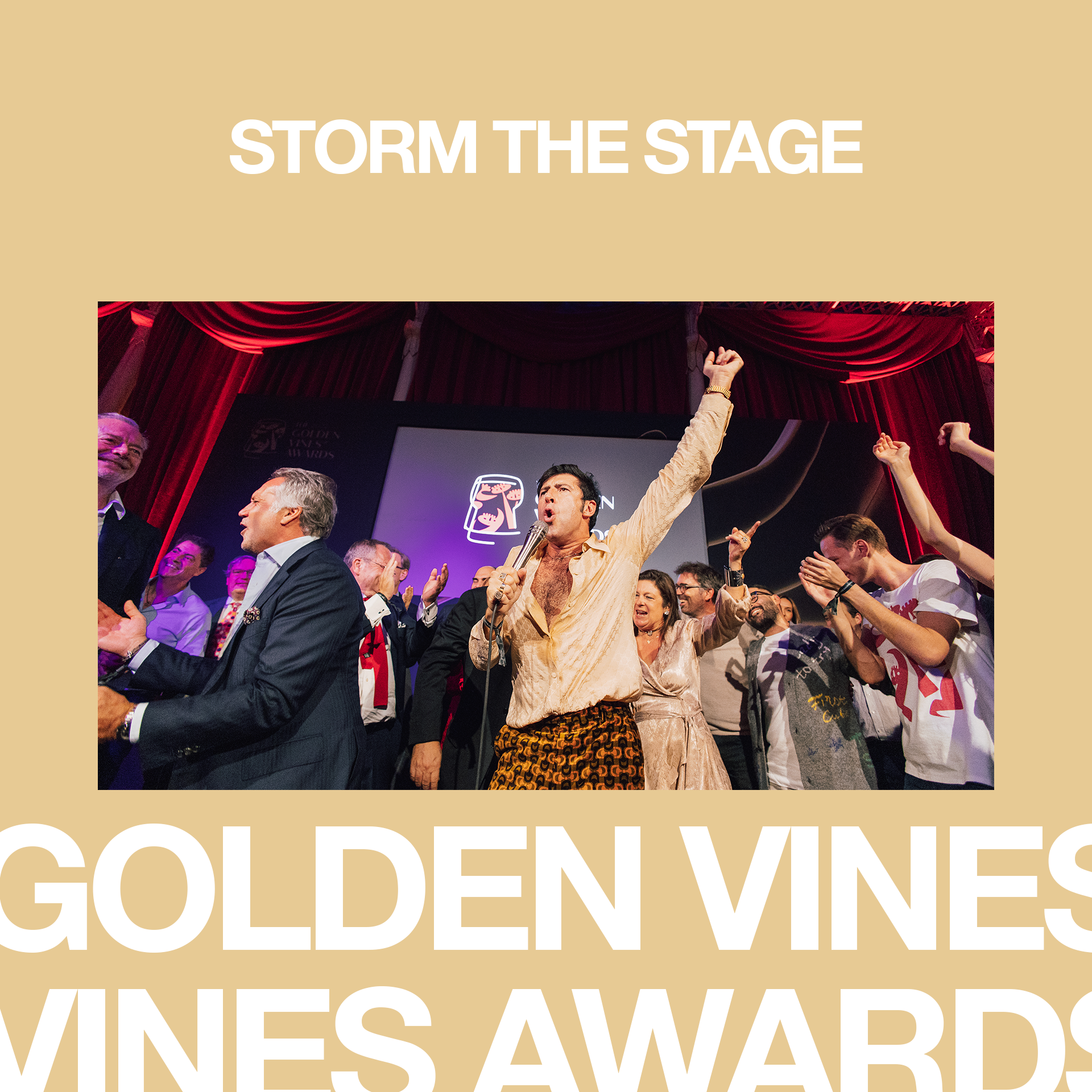 People celebrating on stage at an awards event with red curtains in the background, raising their hands and clapping.