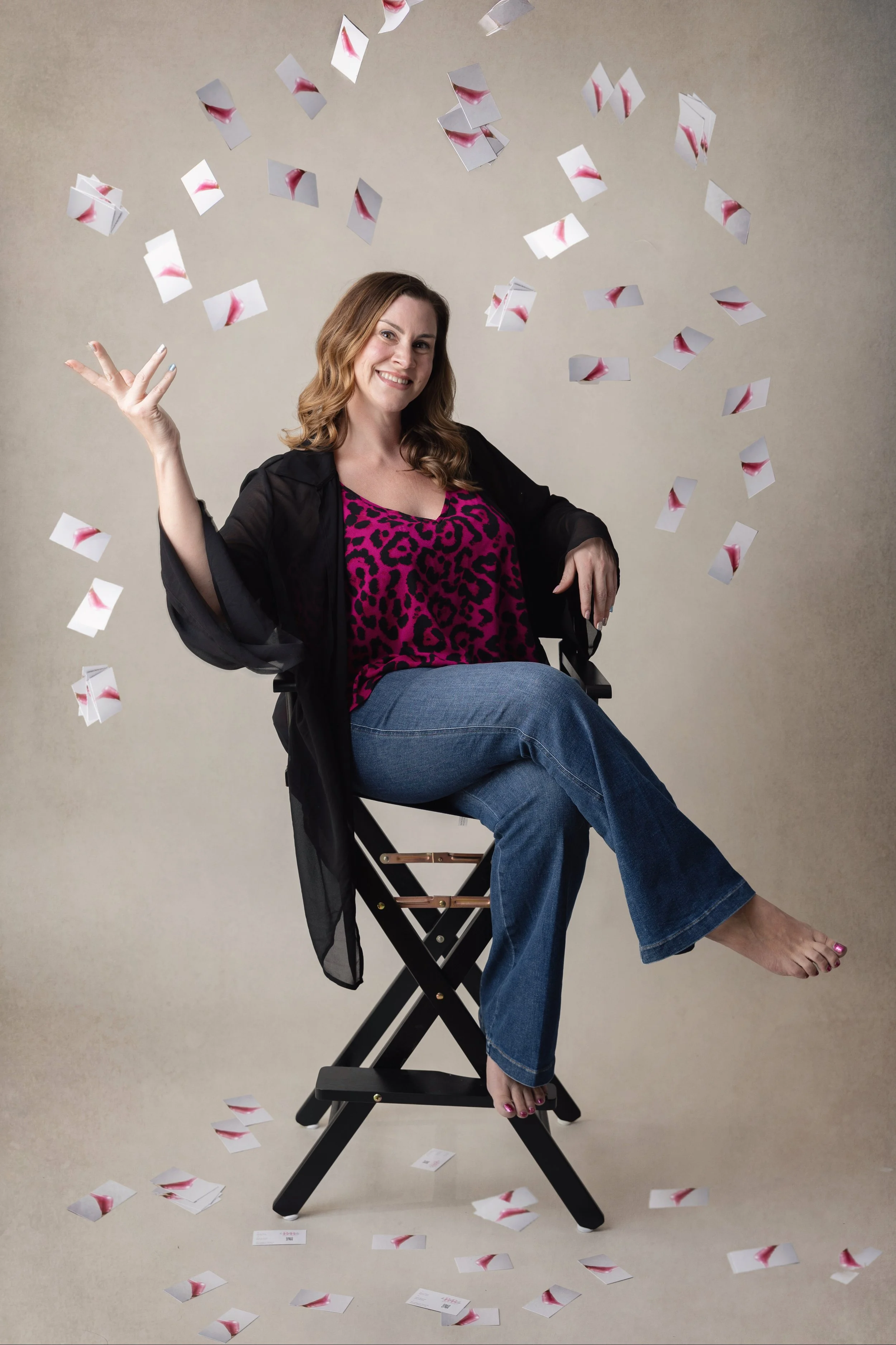Licensed Esthetician sitting on chair, hand up and business cards falling down around her