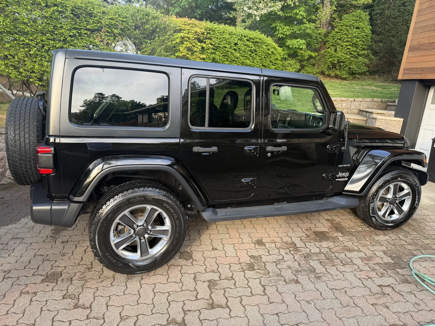 Black Jeep Wrangler freshly detailed in wooded Pelham NY setting