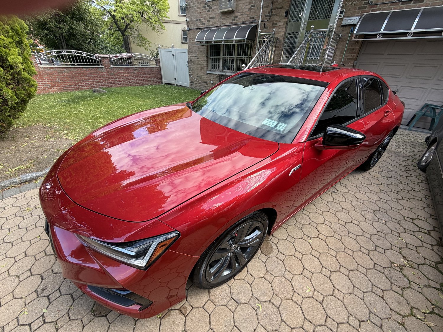 Red Acura TLX freshly detailed on Bronxville brick driveway
