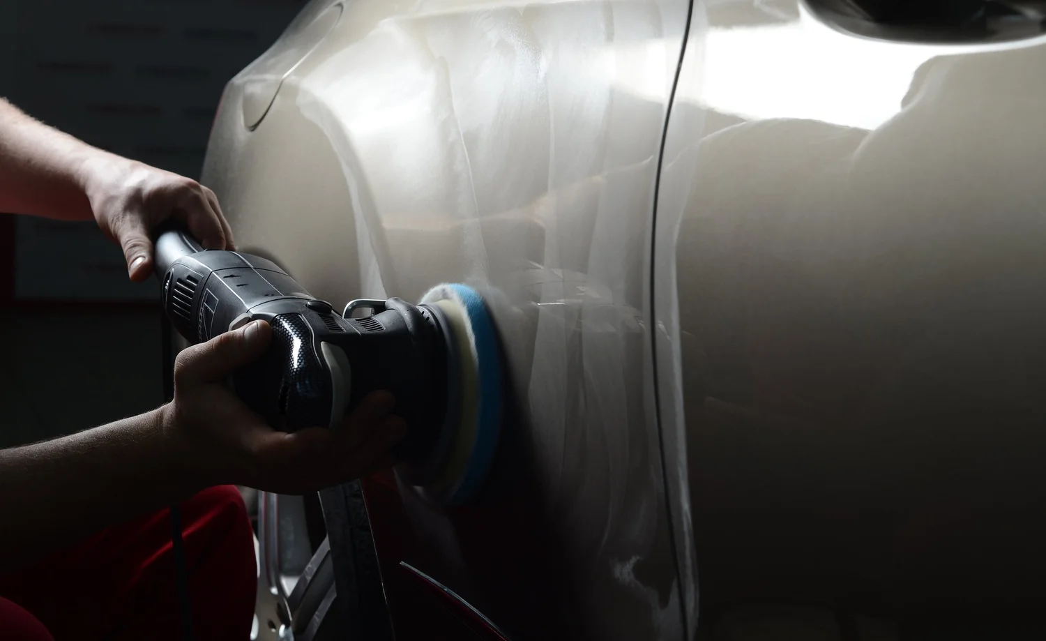 Machine polisher working on vehicle paint during correction