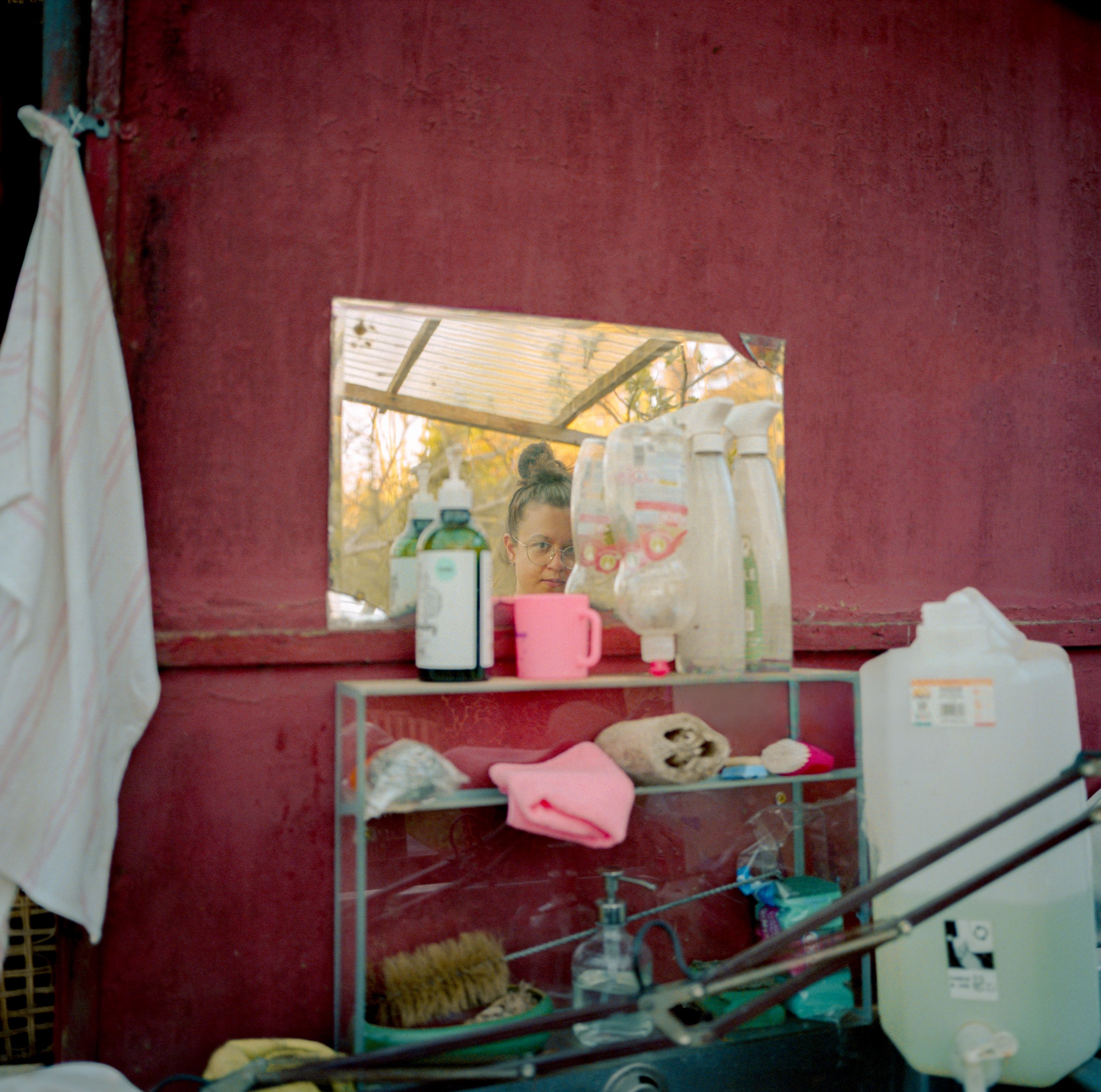 Woman in the mirror of outdoor kitchen sink