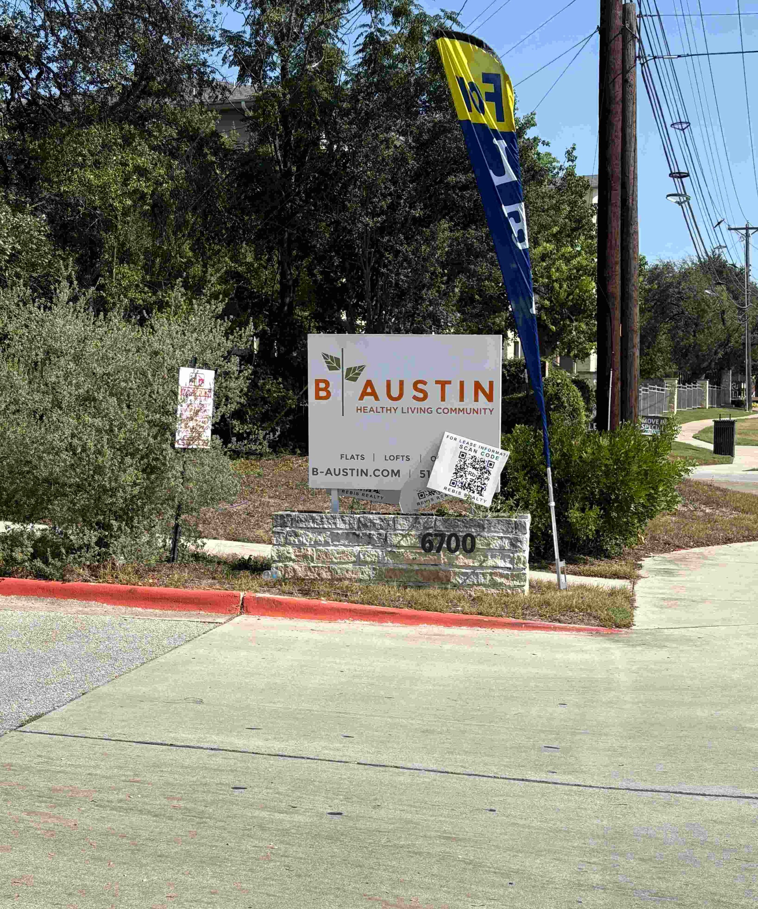 A white sign with orange lettering that reads "B Austin."
