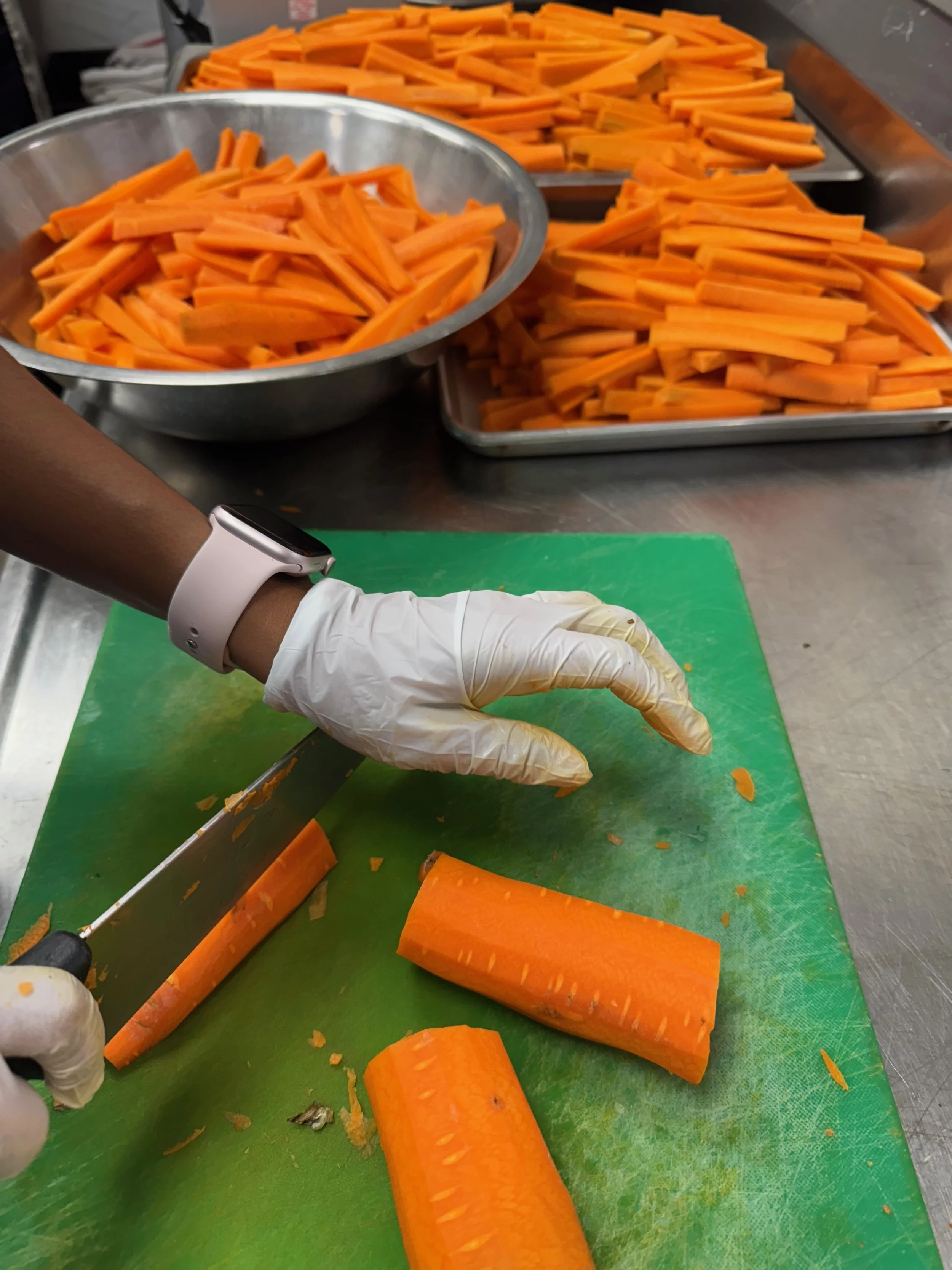 A Washington College intern prepping carrots to ferment