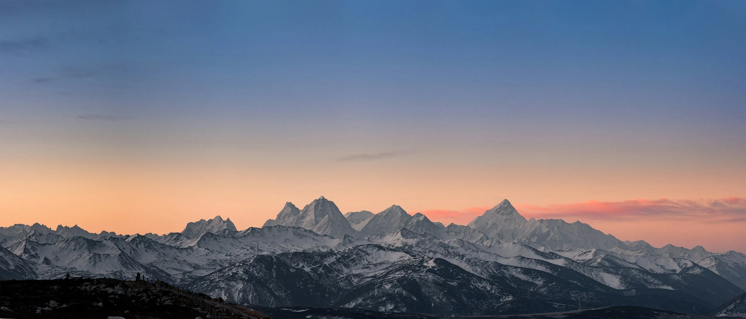 indigo blue and peachy pink sunset snowy mountains