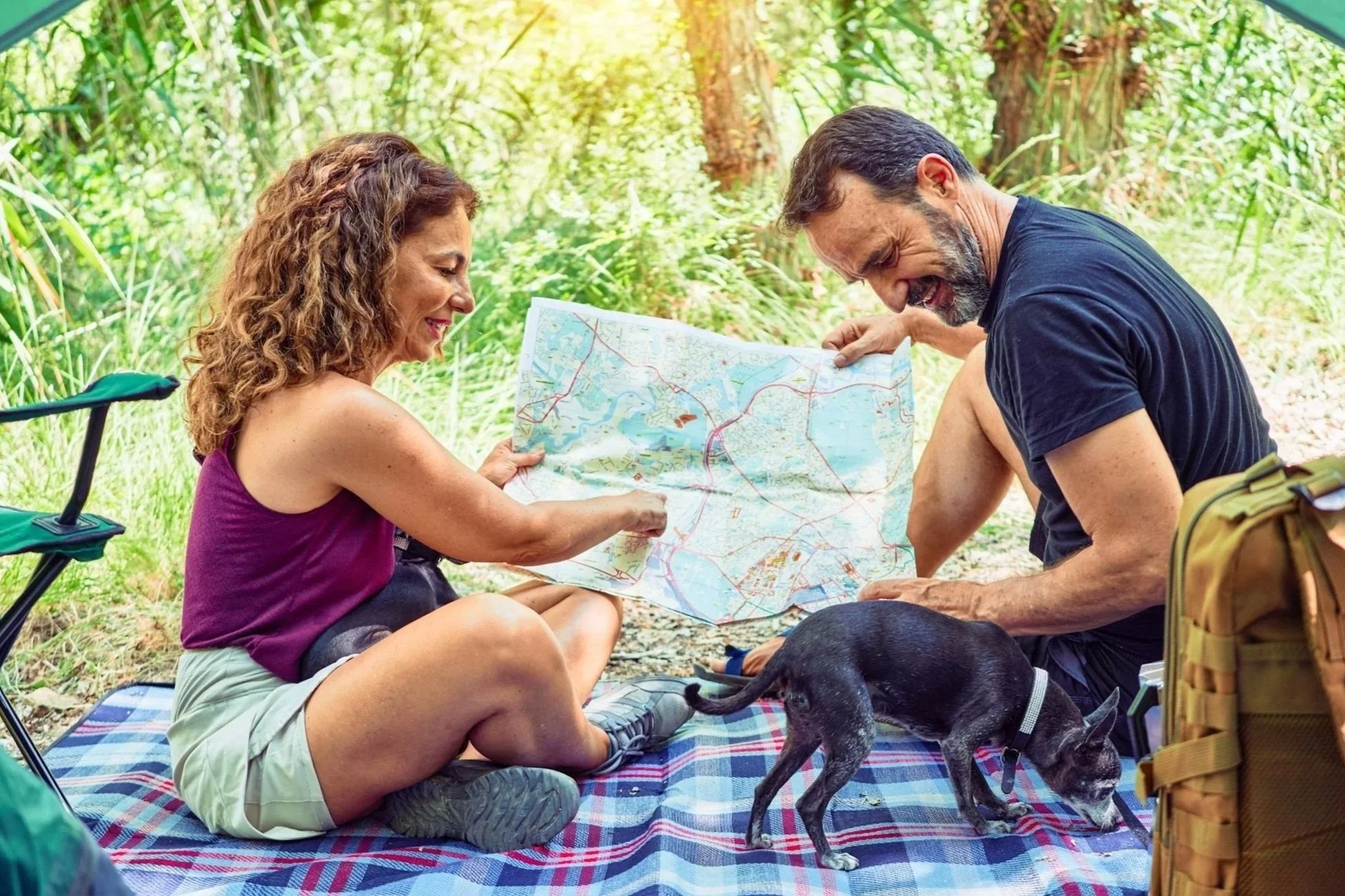 middle-age men and woman camping with dog and Superior Quad molle backpack