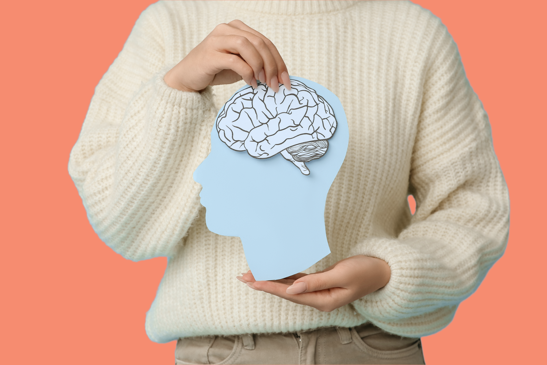 woman holding brain profile paper cut out