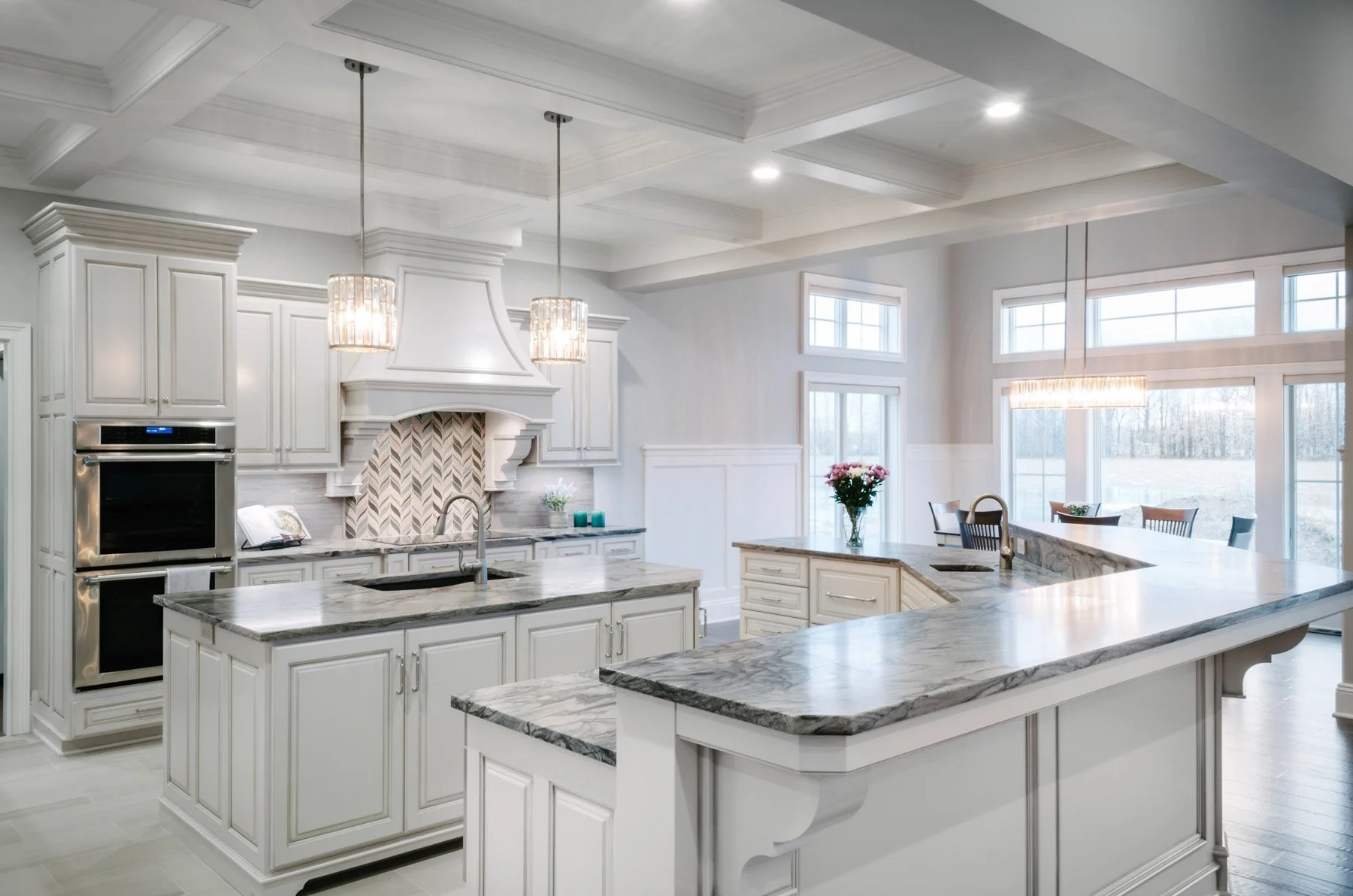 Custom kitchen in Columbia Station, OH with half wall counter and bar top in front, island middle, and cabinets, range, and wall ovens against far wall