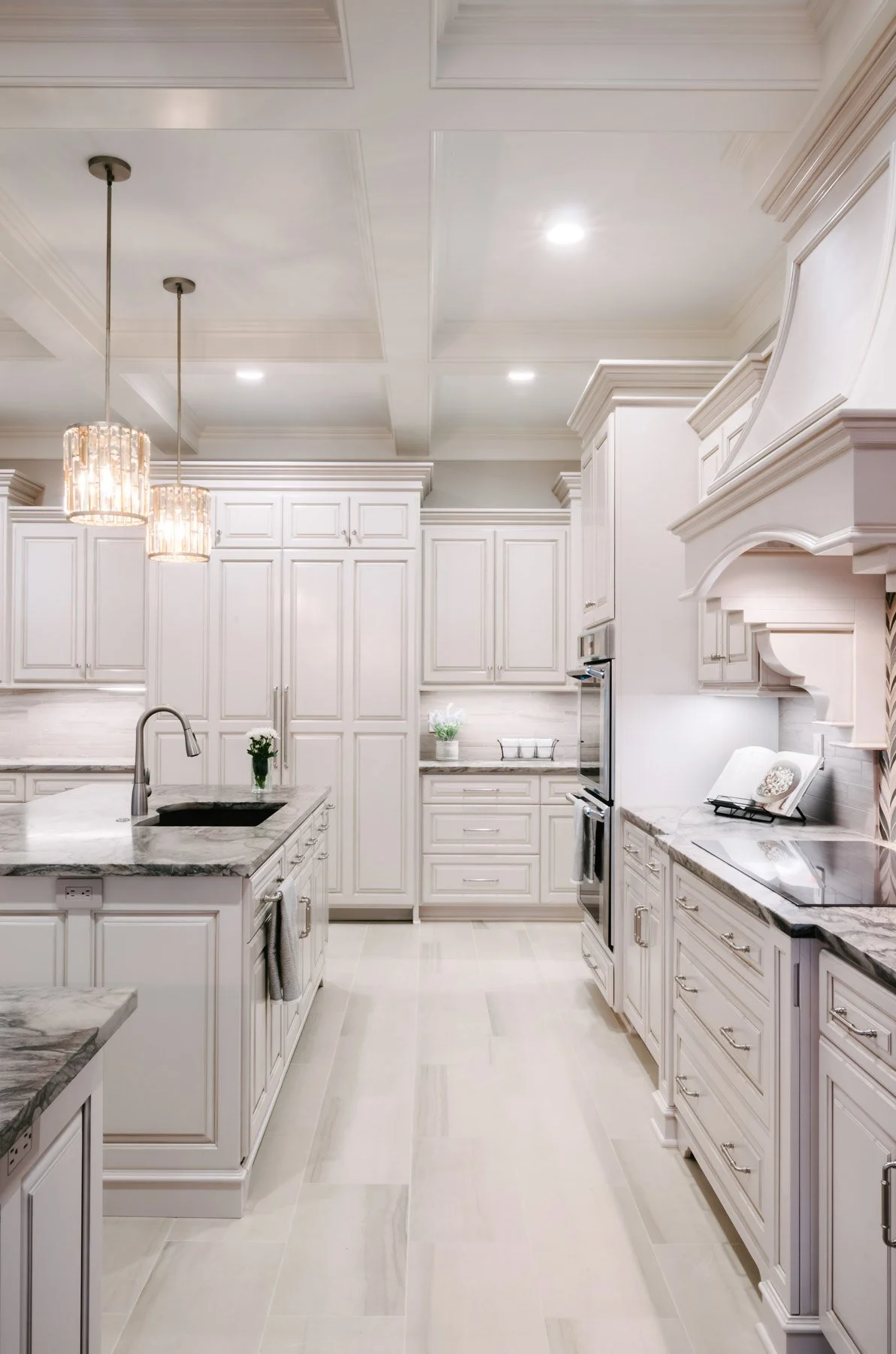 Galley view of custom kitchen with island and back counter with range and ovens
