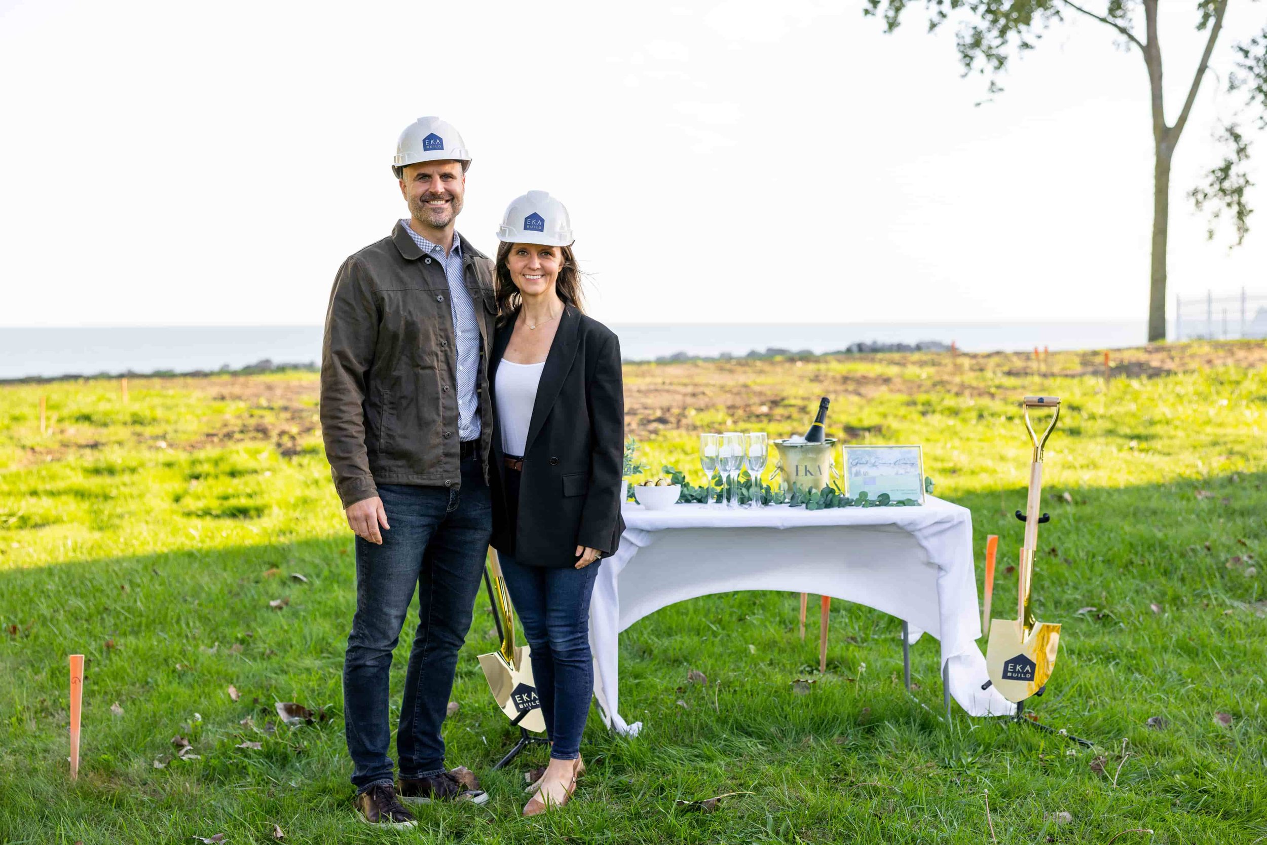 EKA Build founders Ed and Angelica Kisiel wearing hard hats at a custom home construction site