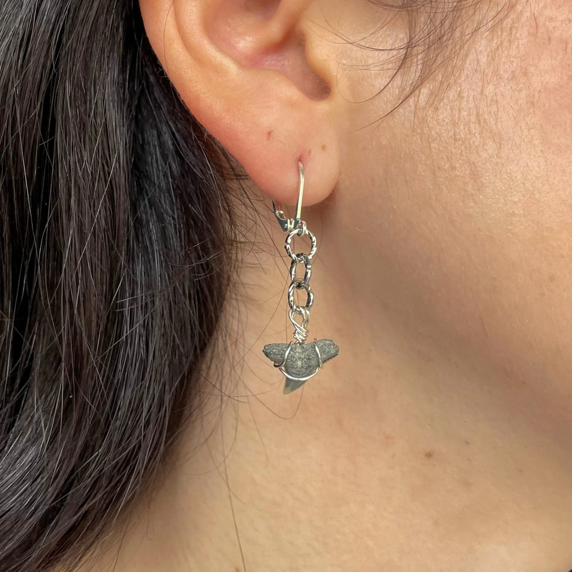 Short silver shark tooth dangle earrings wearing.jpeg