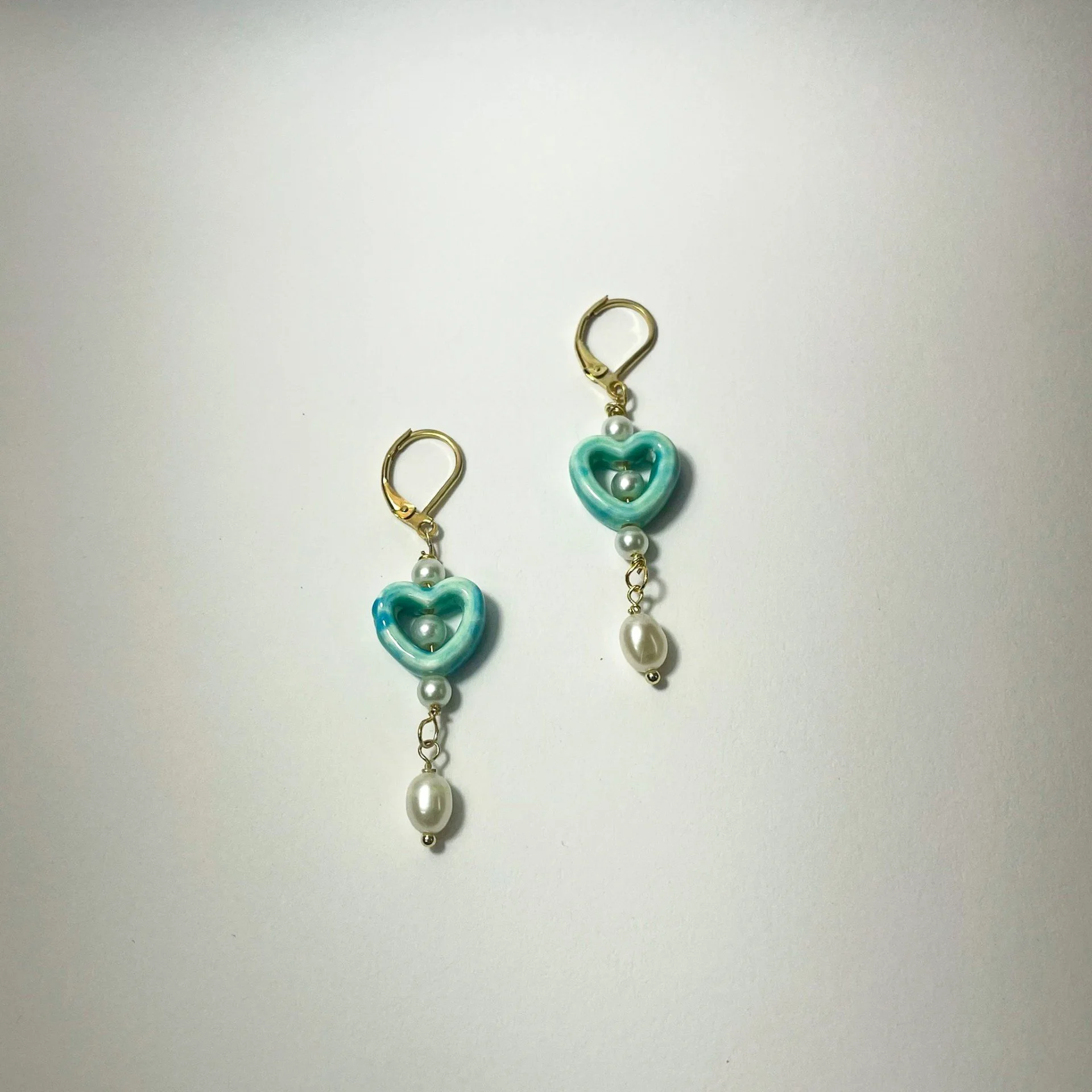 Teal heart earrings staged.jpg