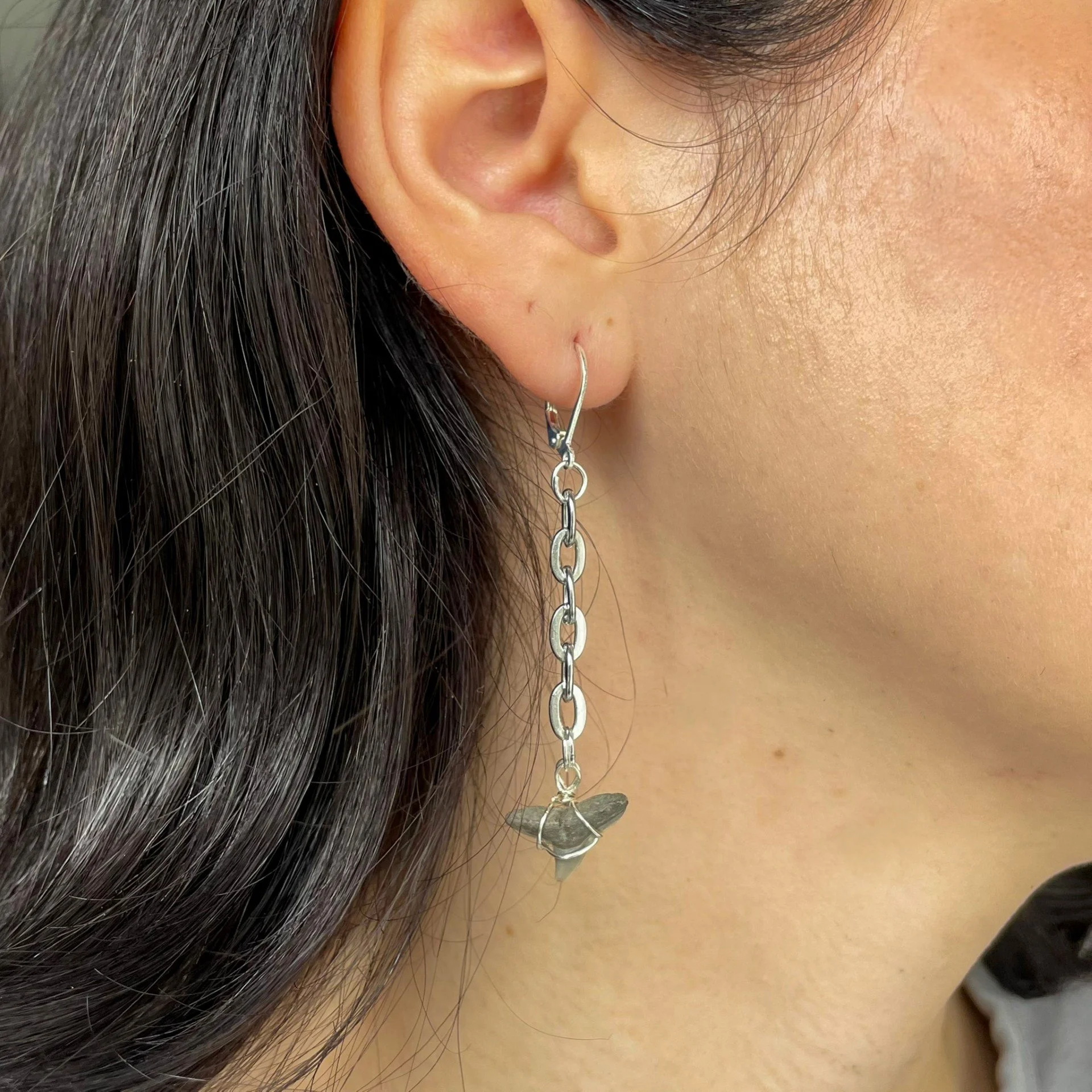 Long silver shark tooth dangle earrings wearing.jpeg