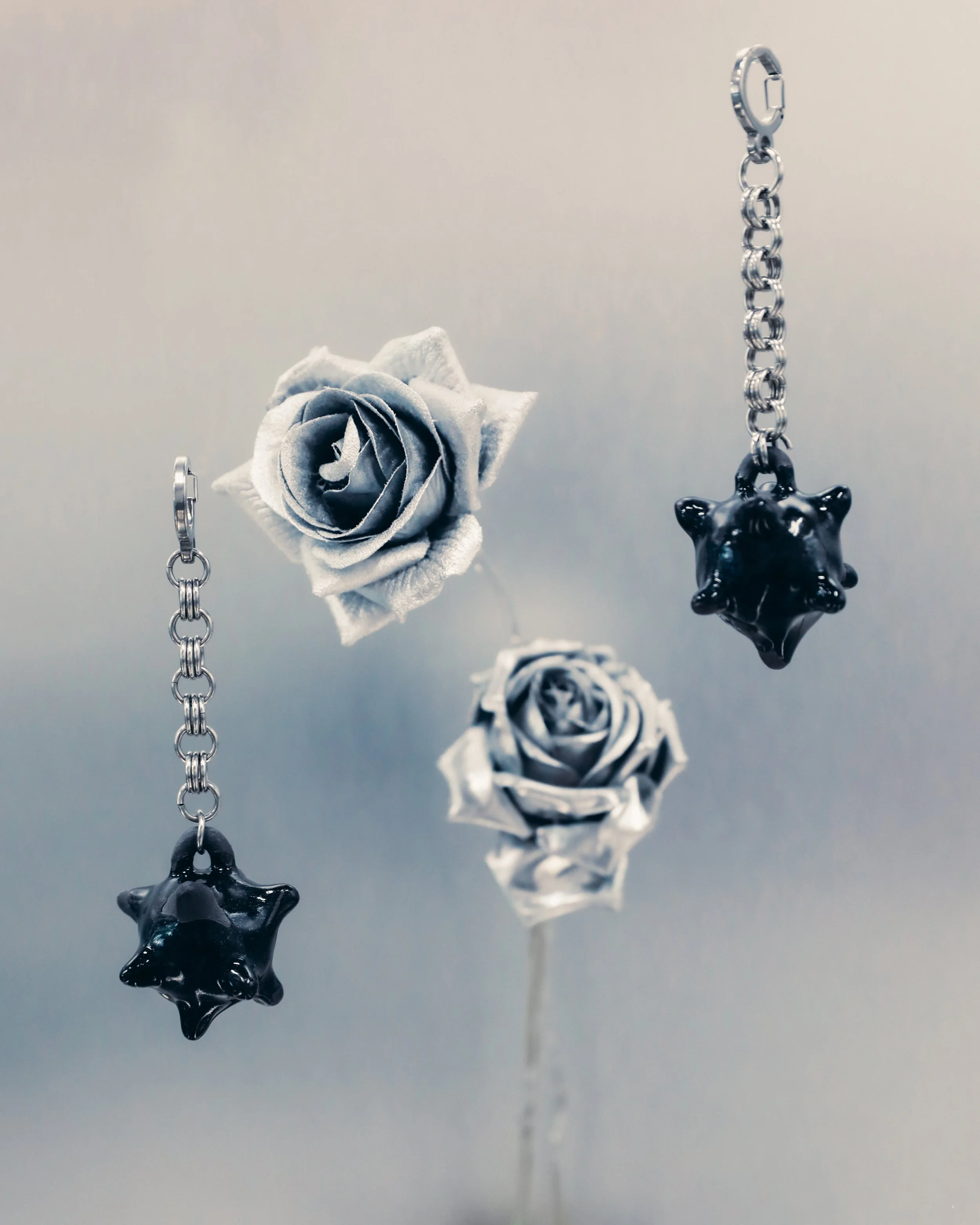 Black mini mace keychains photographed with metallic roses 