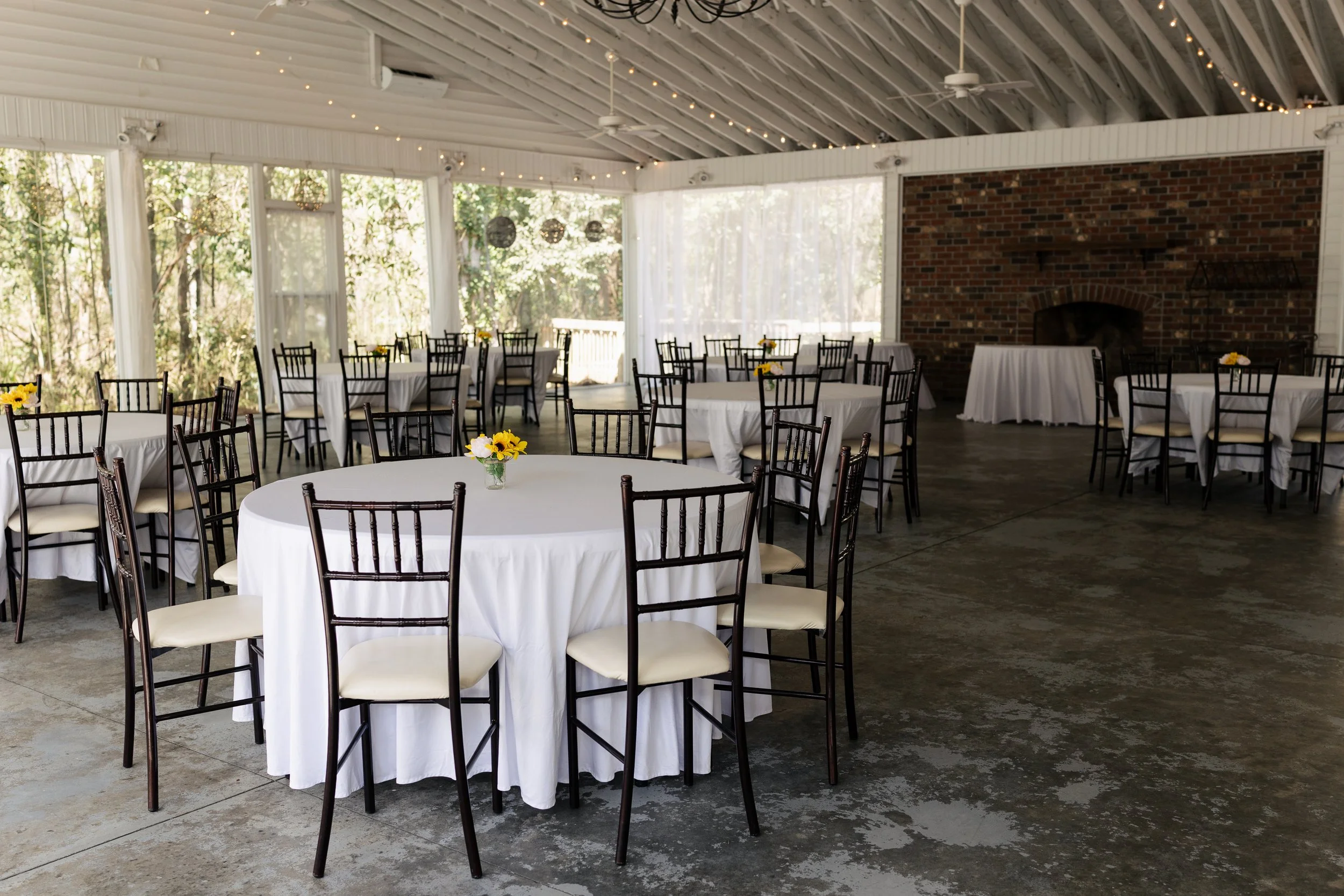 Indoor wedding reception setup at 108 W Main in Moncks Corner, SC with round tables, white linens, and a climate-controlled pavilion.