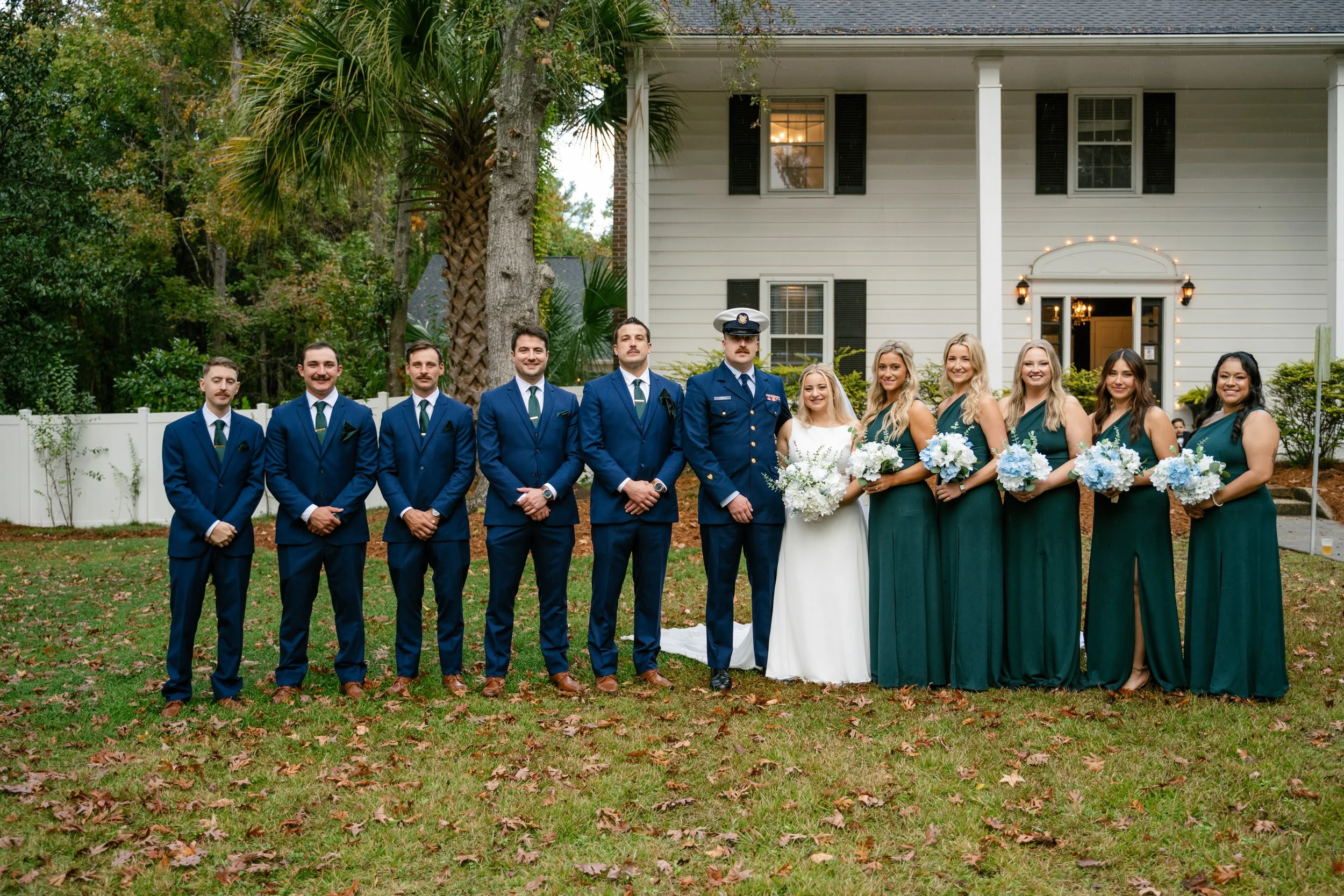 Wedding party portrait with bride, groom, and bridesmaids in front of 108 W Main, Moncks Corner, SC.