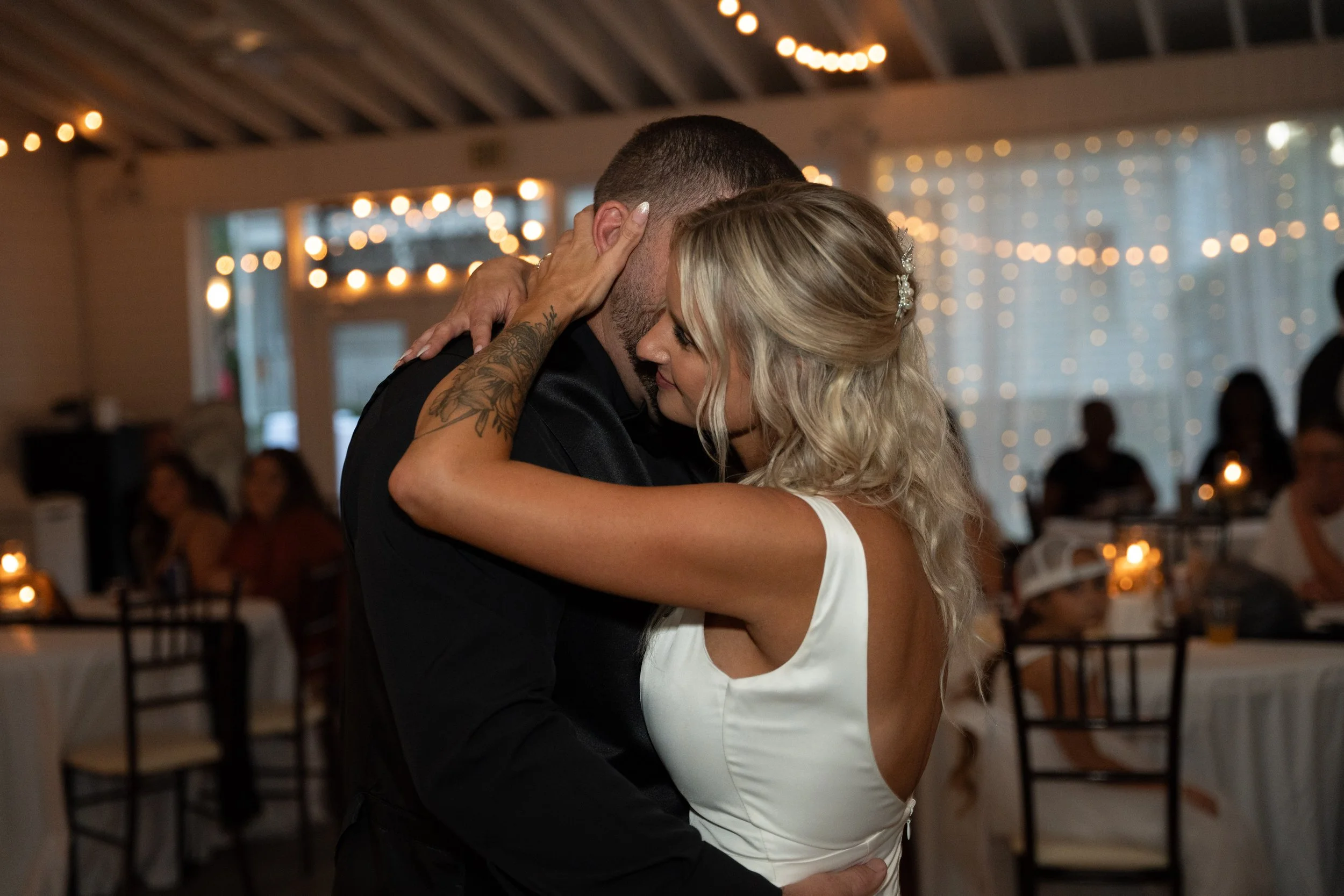 Couple dancing at their wedding reception under string lights in the pavilion at 108 W Main, Moncks Corner, SC
