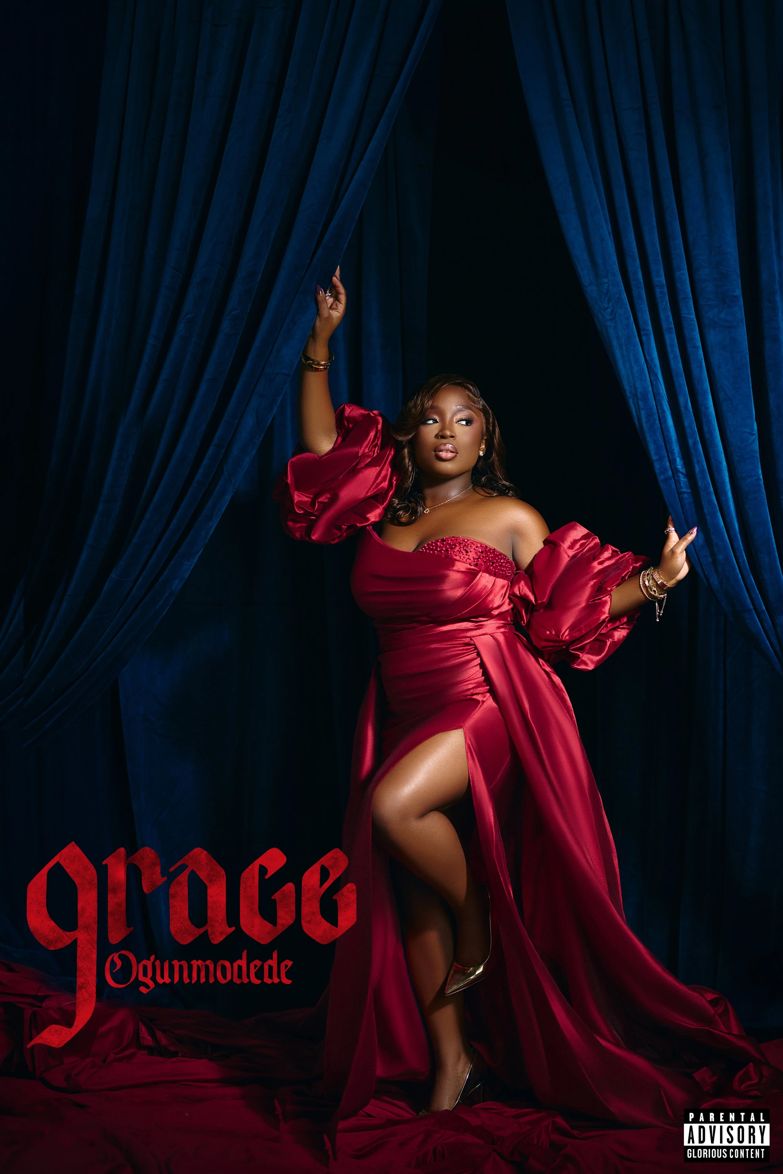 Woman in an elegant red gown standing in a luxurious setting with chandeliers, red drapery, and mirrored disco balls.