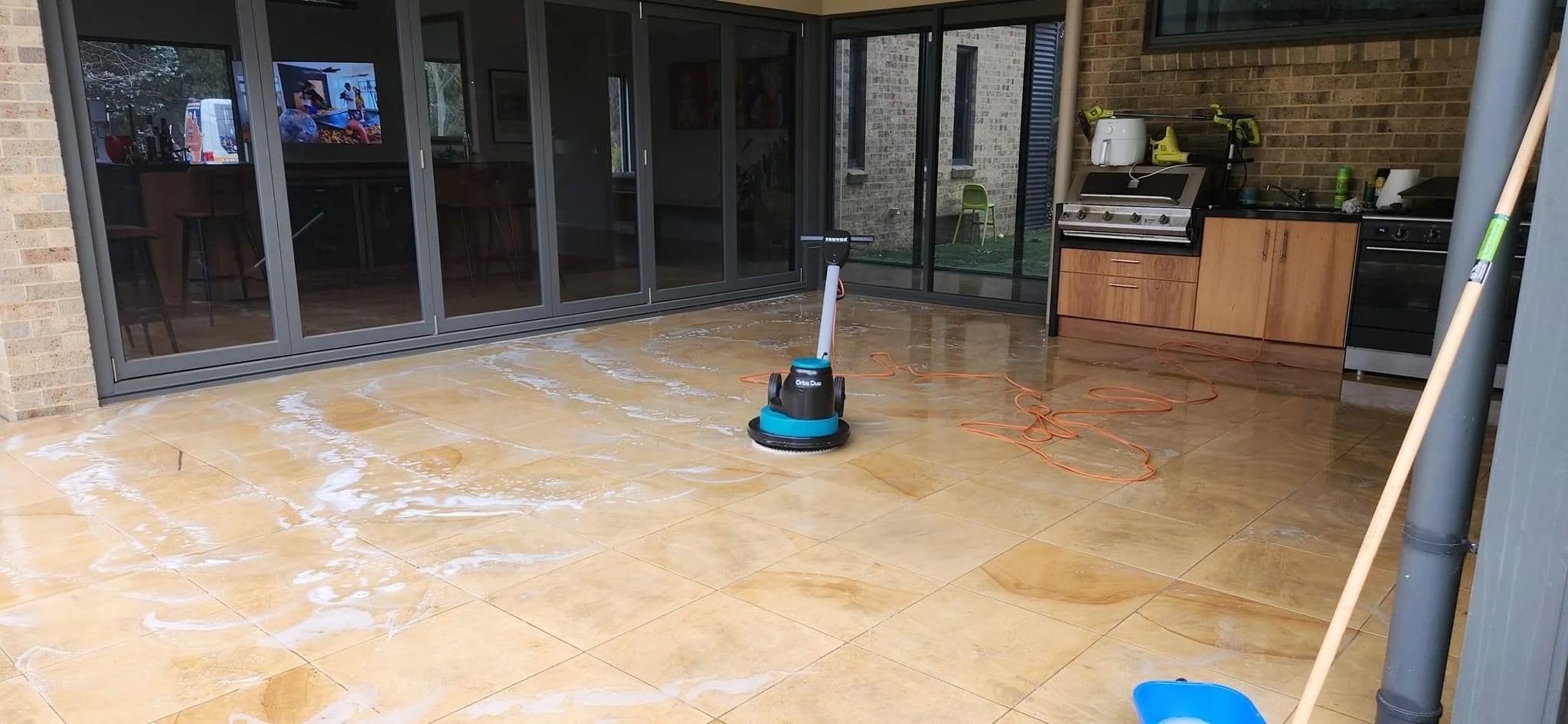 Industrial cleaning machine on top of wet soapy outdoor tiles