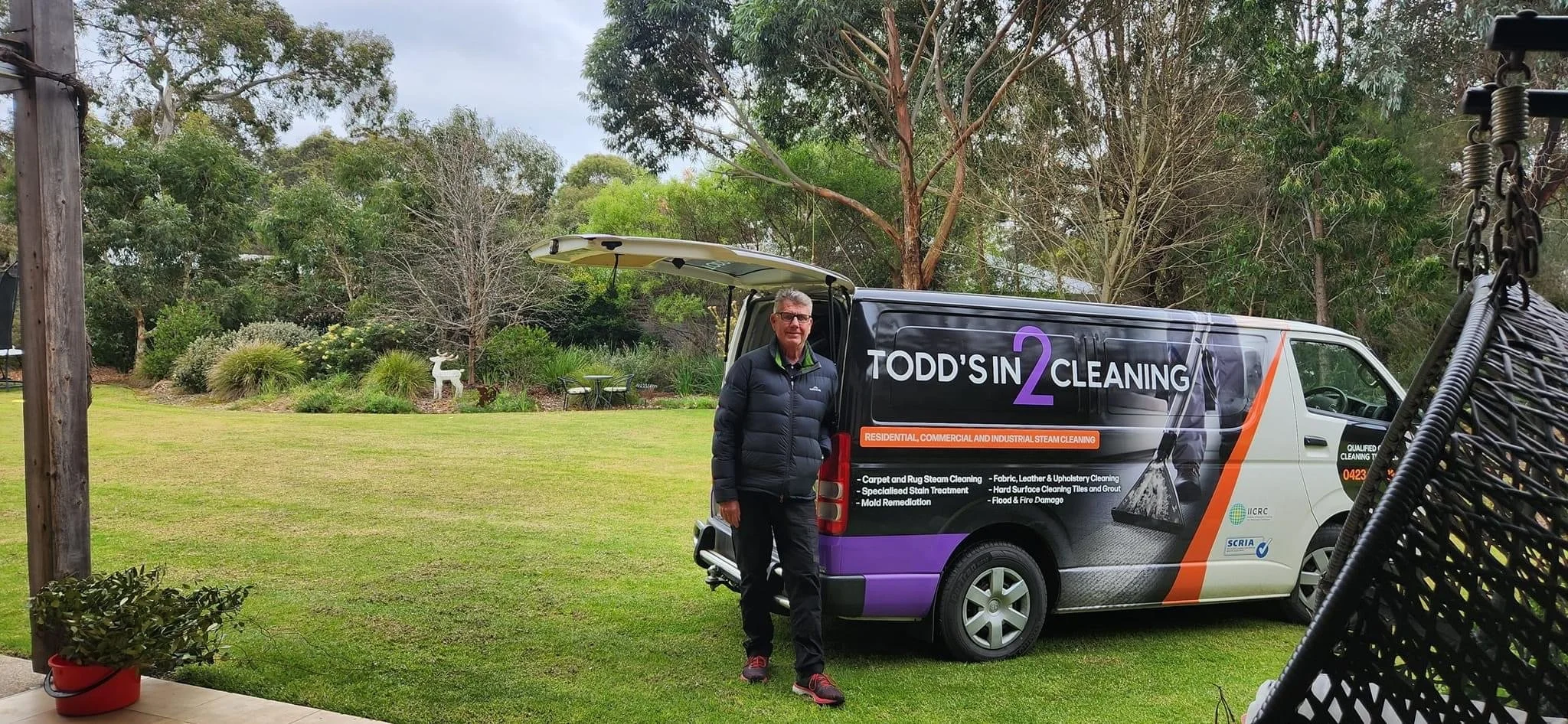 Man standing on grass next to cleaning company van