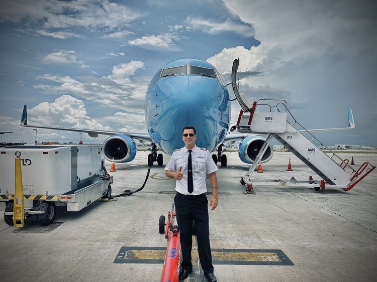 storm chaser Caleb Elliott standing in front of the Boeing 737-800 he flies.