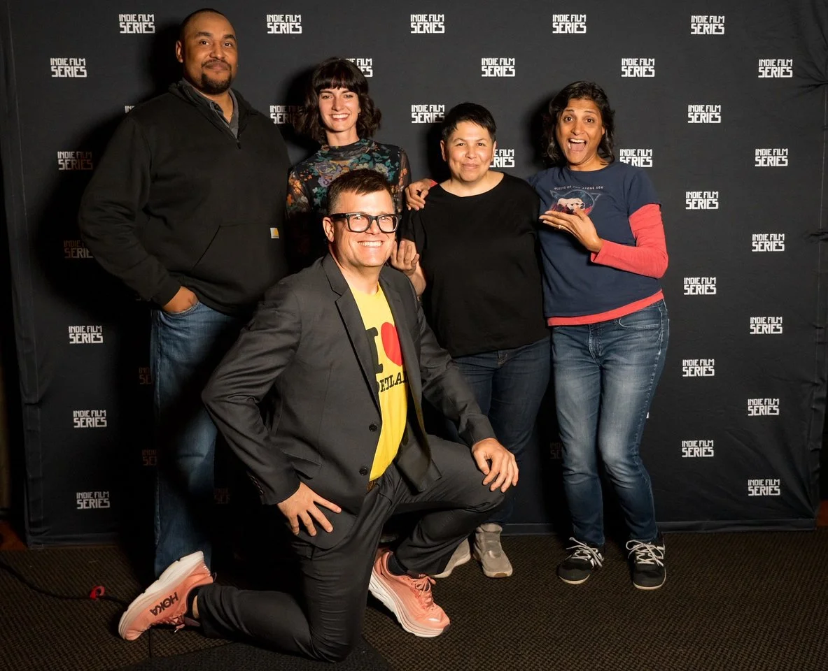 Group of five diverse people posing together at an Indie Film Series event, standing in front of a black backdrop with the event logo.